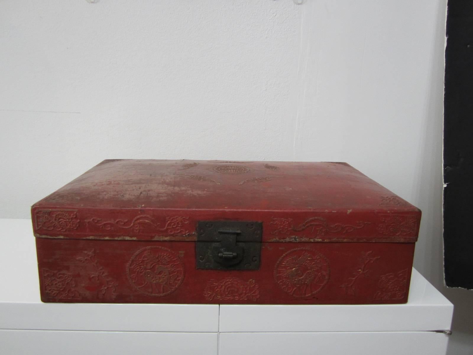 Beautiful Chinese traditional wedding case in red lacquer and blue interior. All original including the iron handles on the sides and the front latch. This case or chest has a lot of raised design all-over and shows a lot of wear but is beautiful