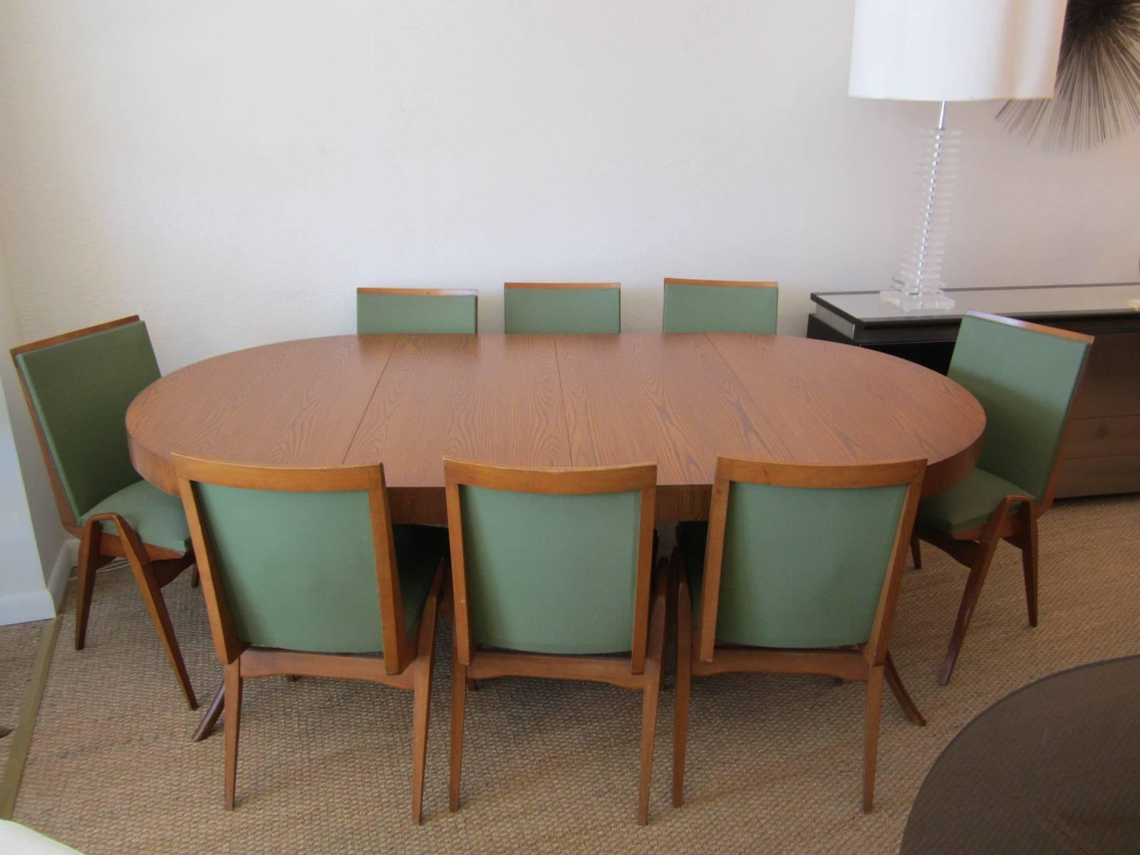 Gorgeous flared leg dining table shown with the two leaves already in place. The table is a perfect circle without the leaves and can be used as a small dinette or as a center table, see images. Designed by T. H. Robsjohn-Gibbings for John Widdicomb