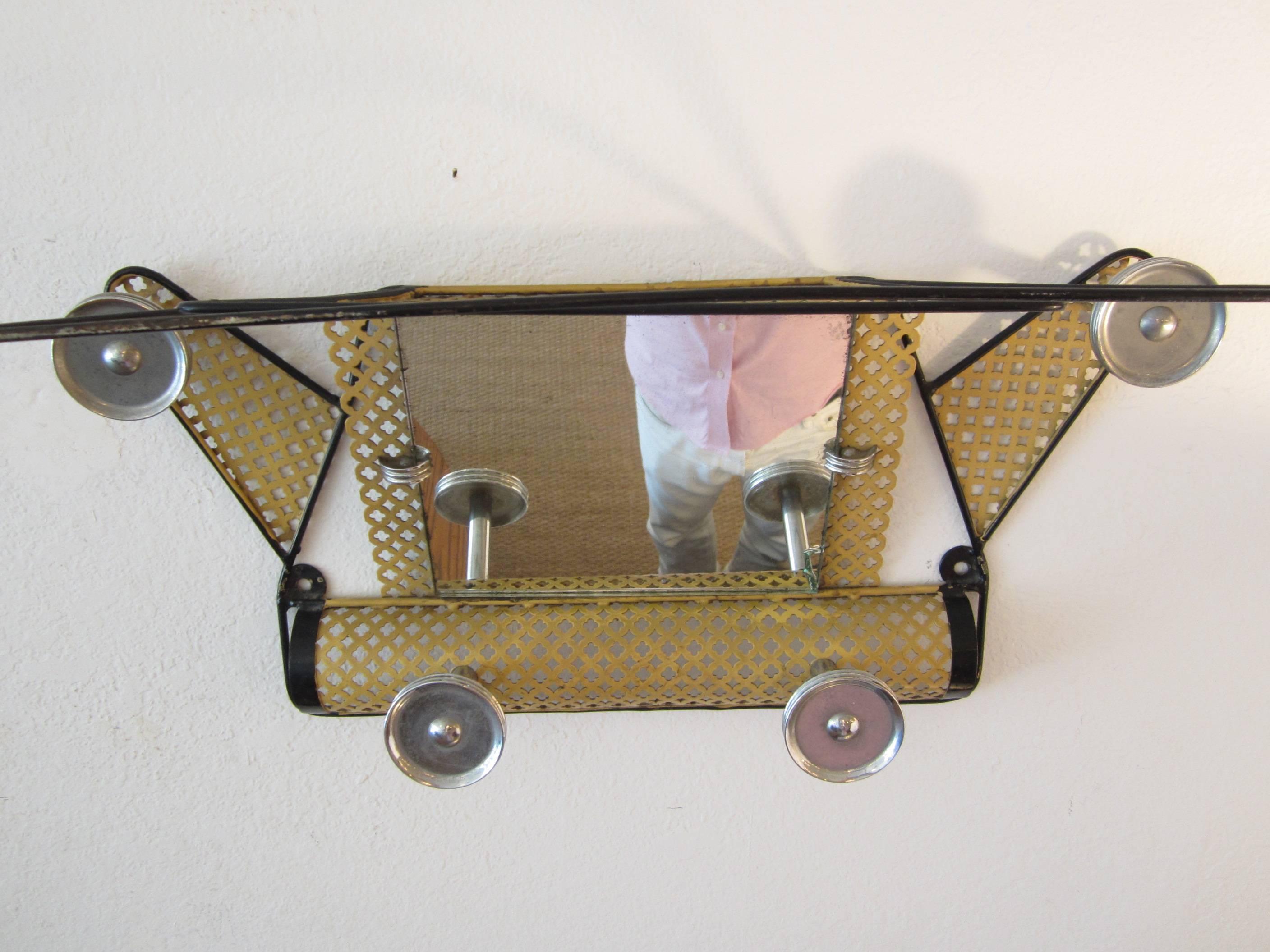 Fantastic pierced metal wall mounted coat rack with top shelf for hats or handbags. Totally original without interrupting its pure state, this coat rack has small rust visible on the bottom but is considered excellent vintage condition. The original