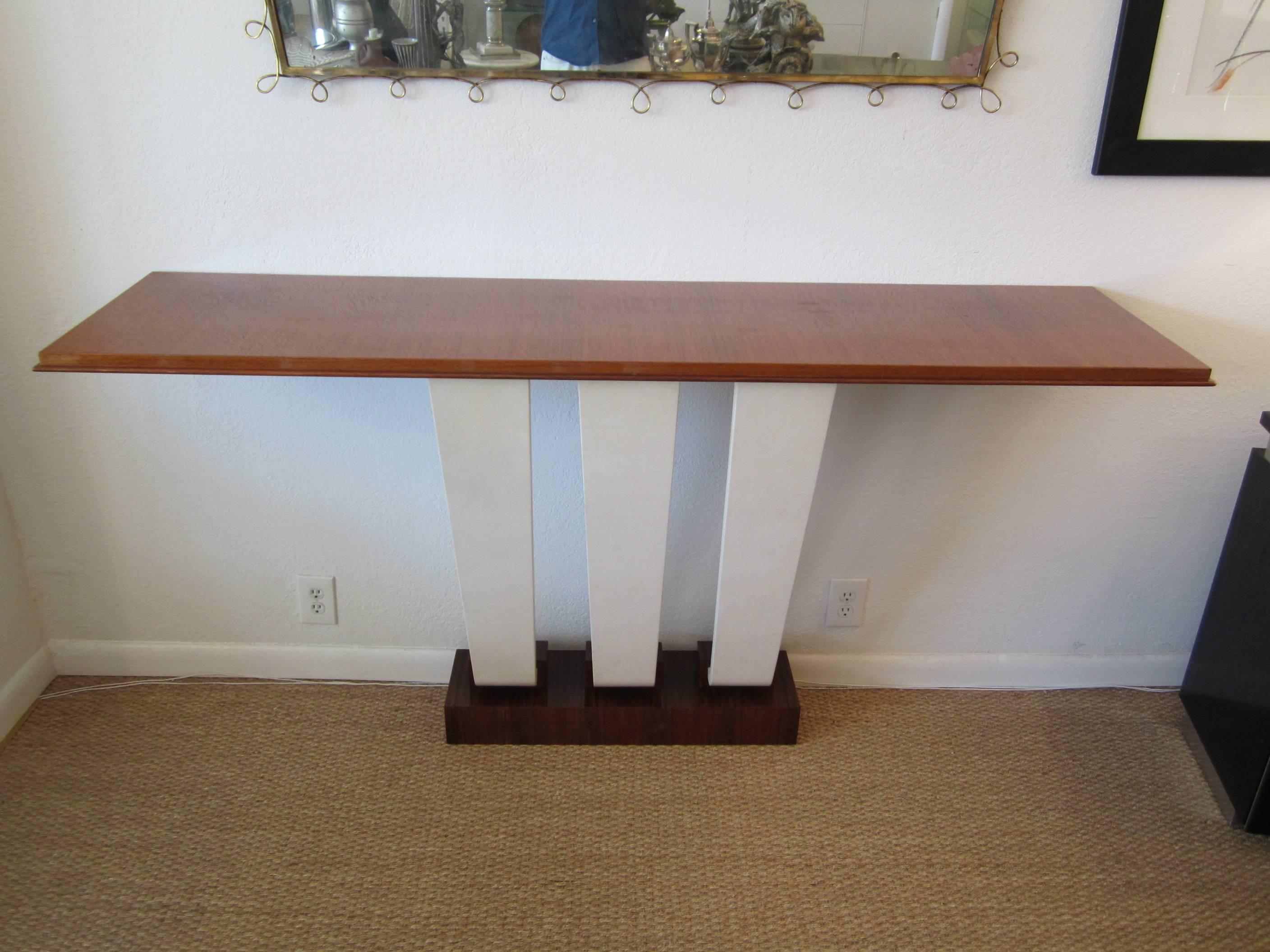 Stunning French Art Deco wall mount console table. The three goatskin covered legs hold the gloss mahogany top and taper inward towards the wall as they go down. Nice thick base in exotic macassar ebony. Small chips on top shelf from natural wear.