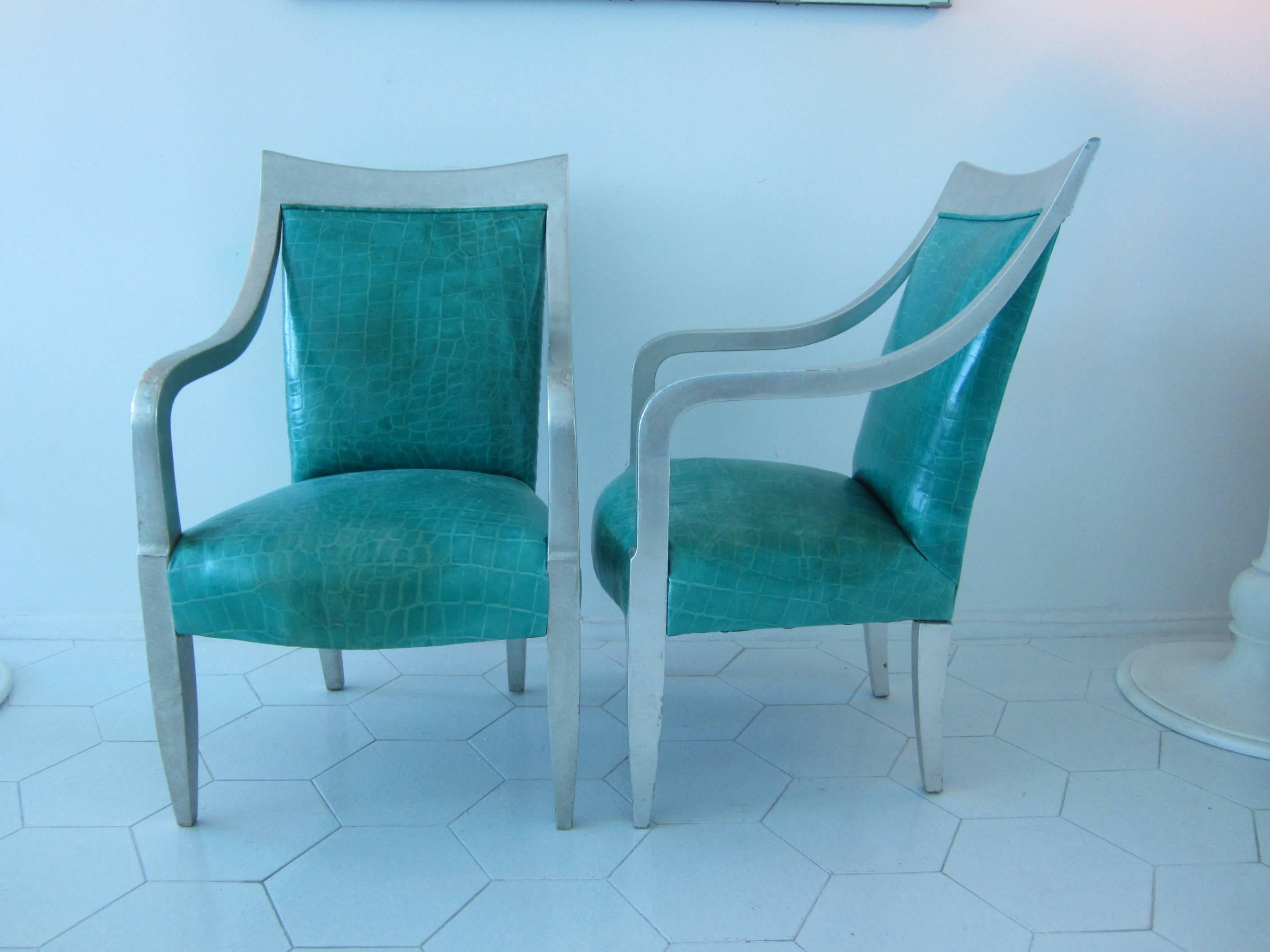 Gorgeous pair of armchairs in silver leaf with turquoise crocodile embossed leather upholstery. Beautiful sweeping frames where arms are continuous from feet to curved frame top. Great scale and naturally worn finishes. Sold as a pair.
