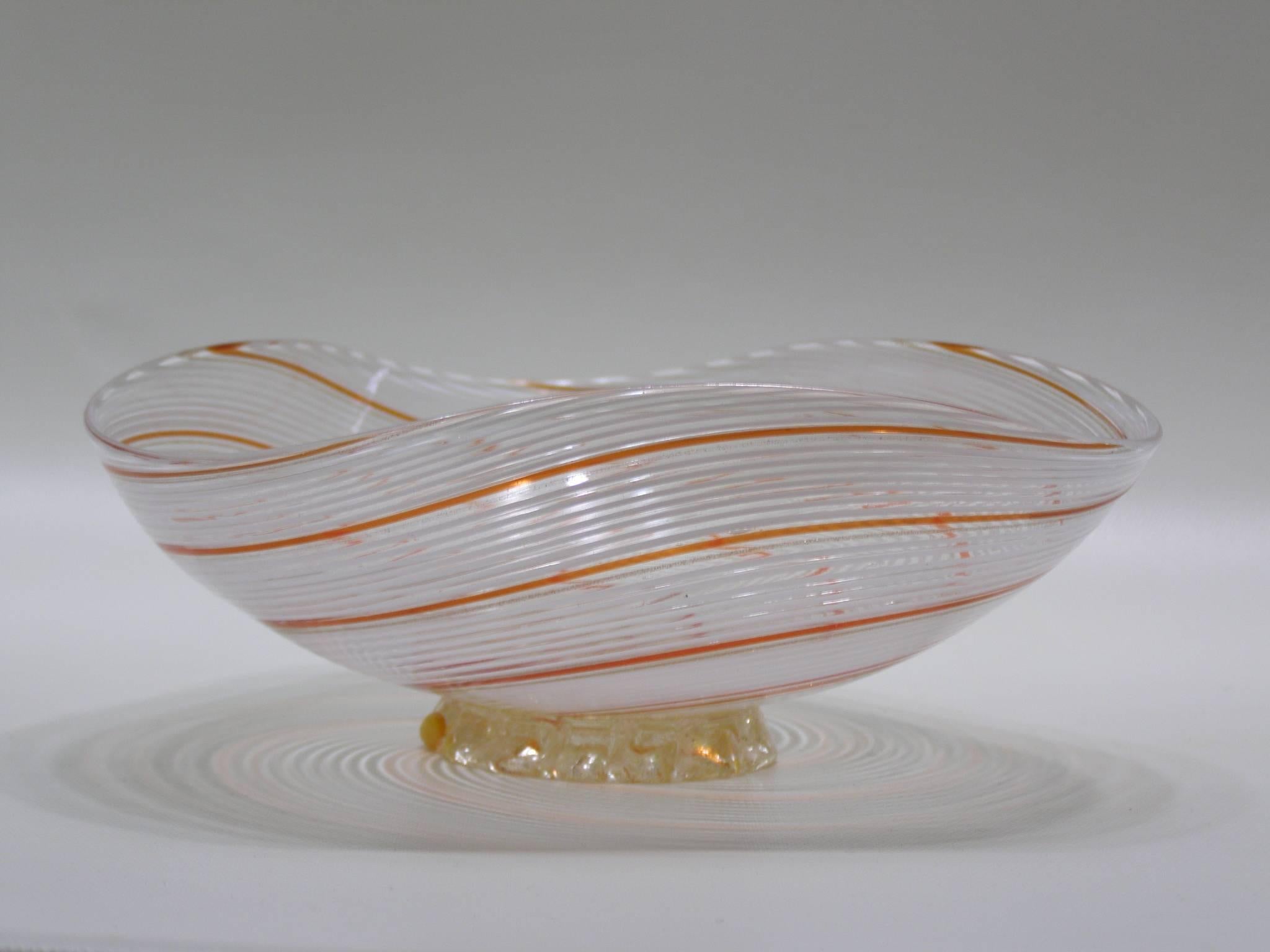 Beautiful Dino Martens handblown Murano glass small catchall bowl with white filigrana combined with an orange swirl stripe and a fused glass base filled with gold leaf flecking. Great on tabletop for useful items and a beautiful display.
