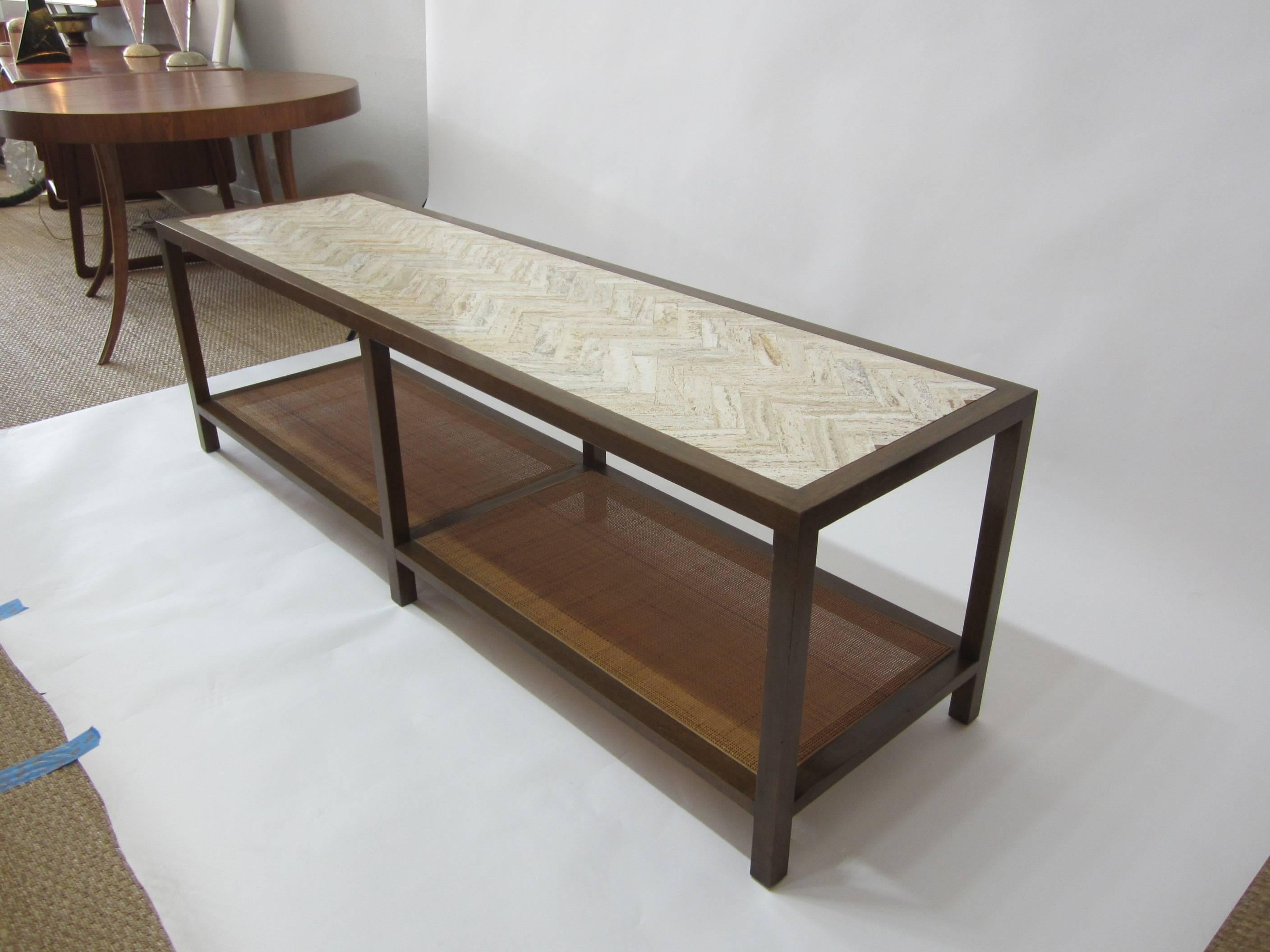 Beautiful two-tier walnut cocktail table which doubles as a bench. Chevron inlay travertine top and cane lower tier. 