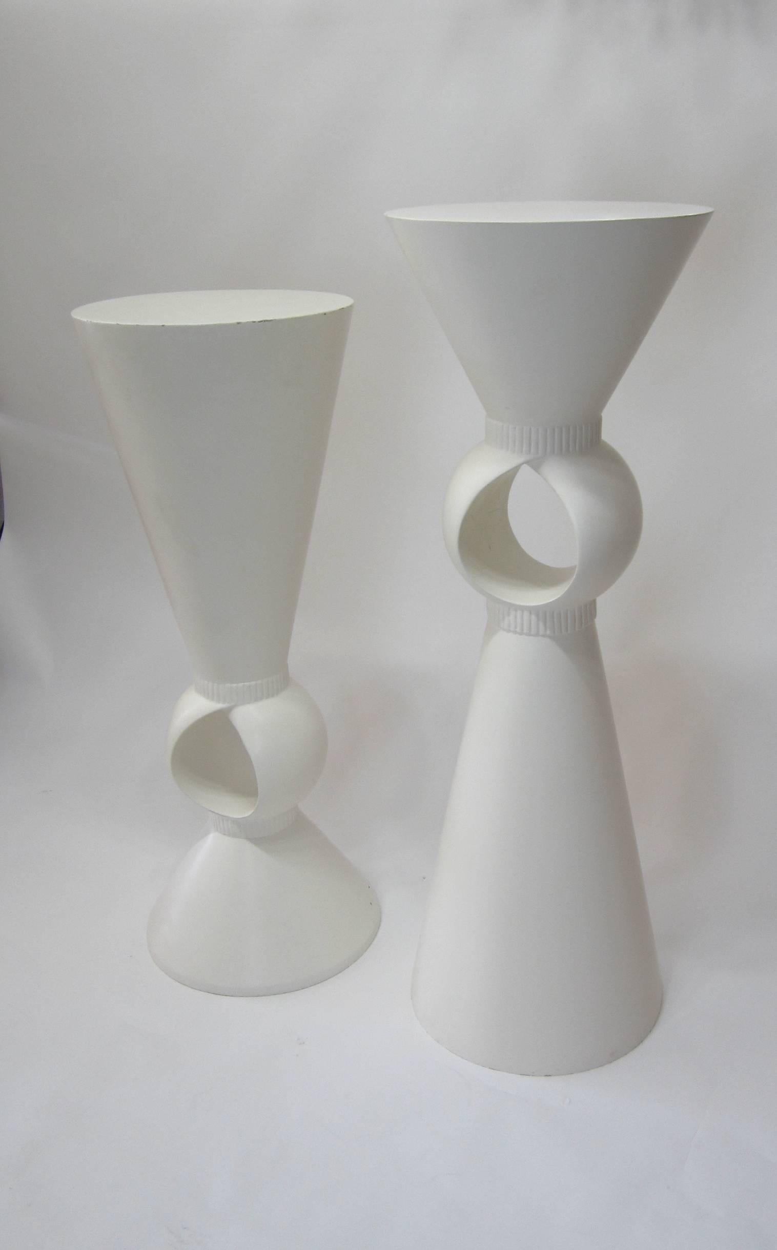 Pair of pedestals measuring forty two inches and forty seven inches tall respectively. Made of composition wood and finished in matte white. The interiors of the hollow centers have a white crackling finish. Great to display art, sculpture,