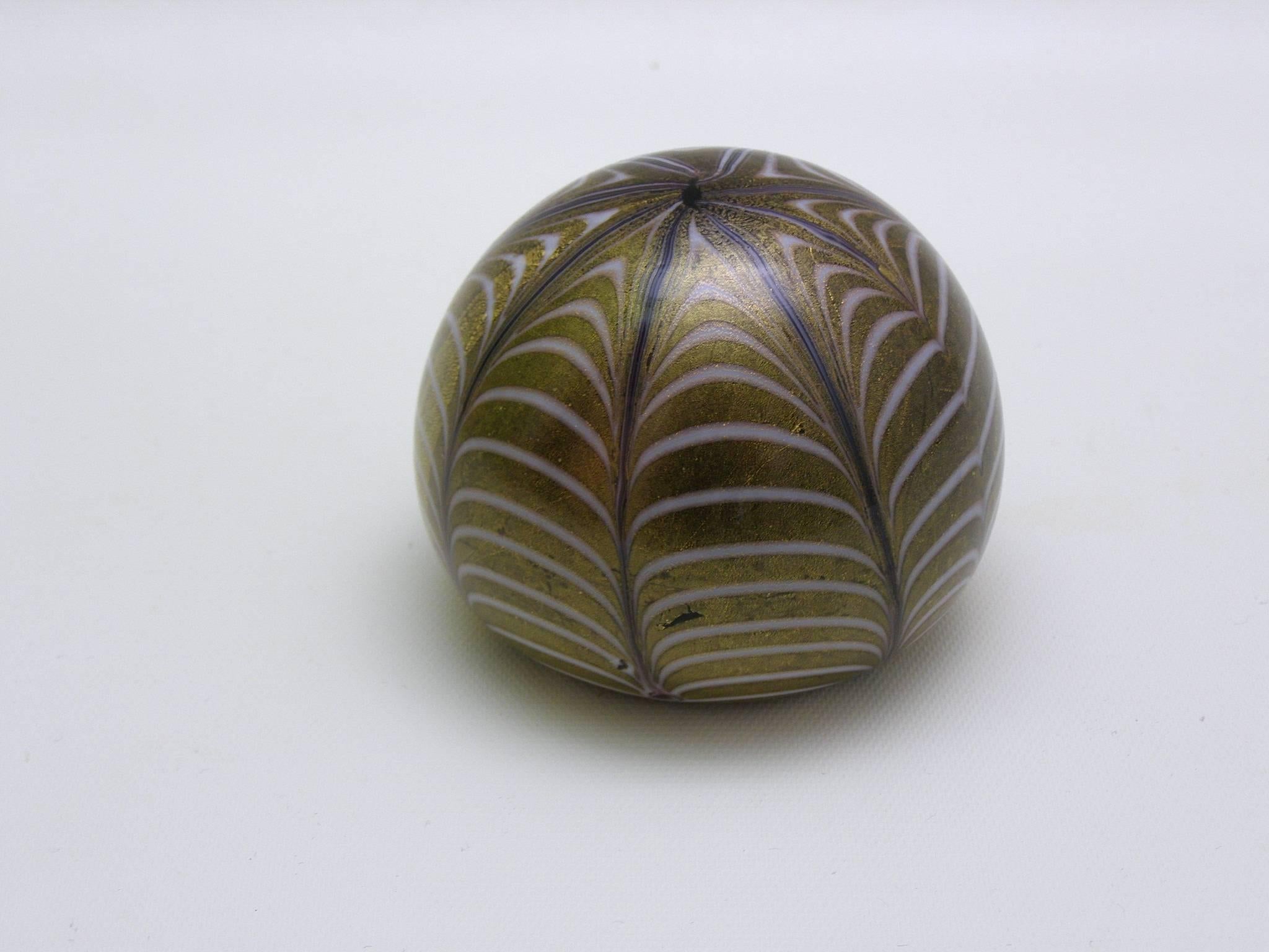 Attractive handblown Murano glass paperweight with a spiderweb pattern. Looking from the top there is a starfish pattern. In hues of gold and green and white, this smooth and precious paperweight is perfect for desktop or for display.