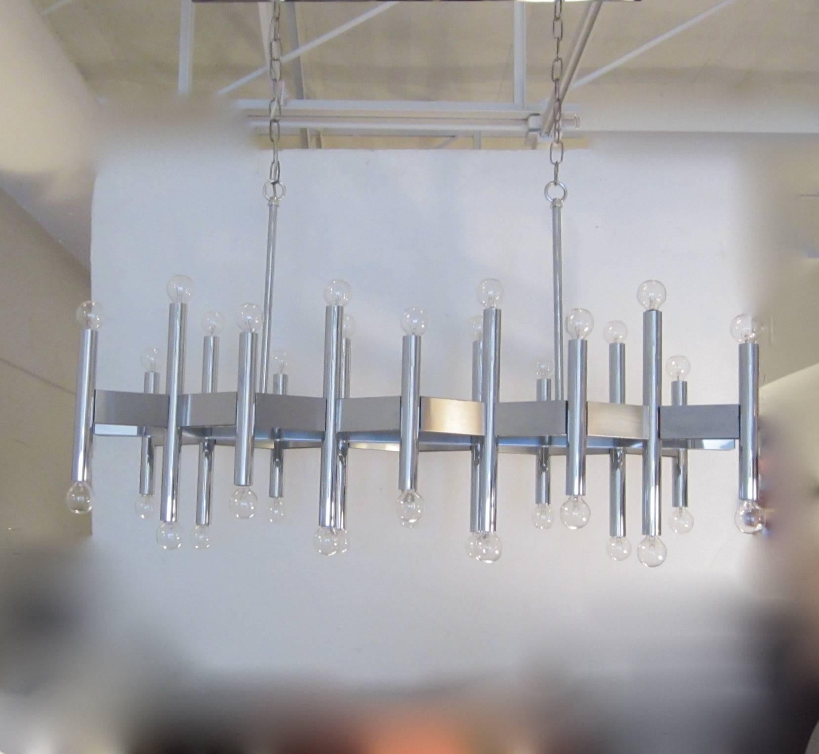 A spectacular 36-light hanging fixture in chrome and steel in a chevron pattern by Gaetano Sciolari. The fixture has rods that extend upwards from the top with hoops that connect to an adjustable chain which then attach to the top rectangular