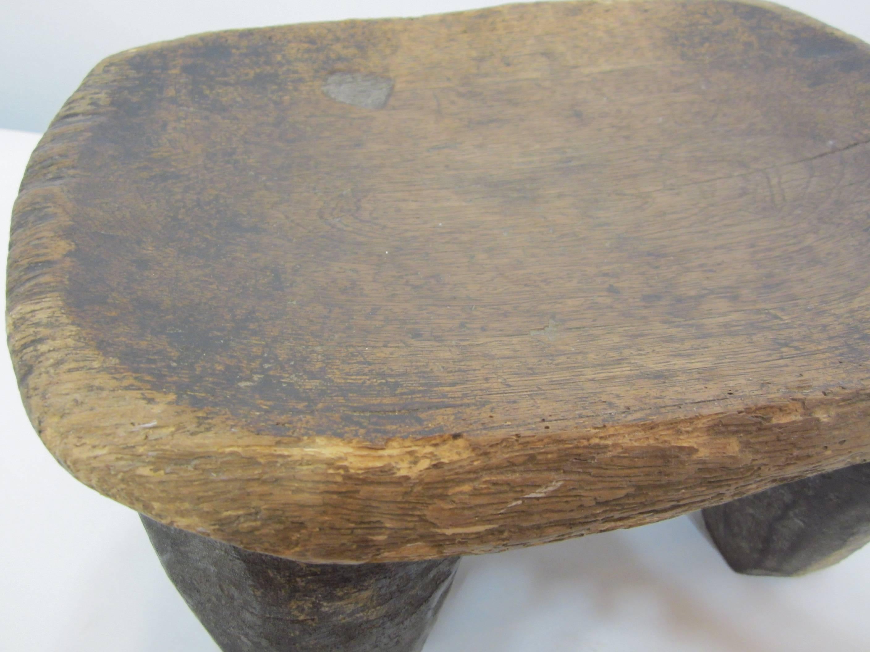 Carved entirely from one one piece of wood, this hand-carved solid wood stool is from the Senufo People in the Cote d'Ivoire, West Africa. A lot of natural patina from age and usage. Solid.