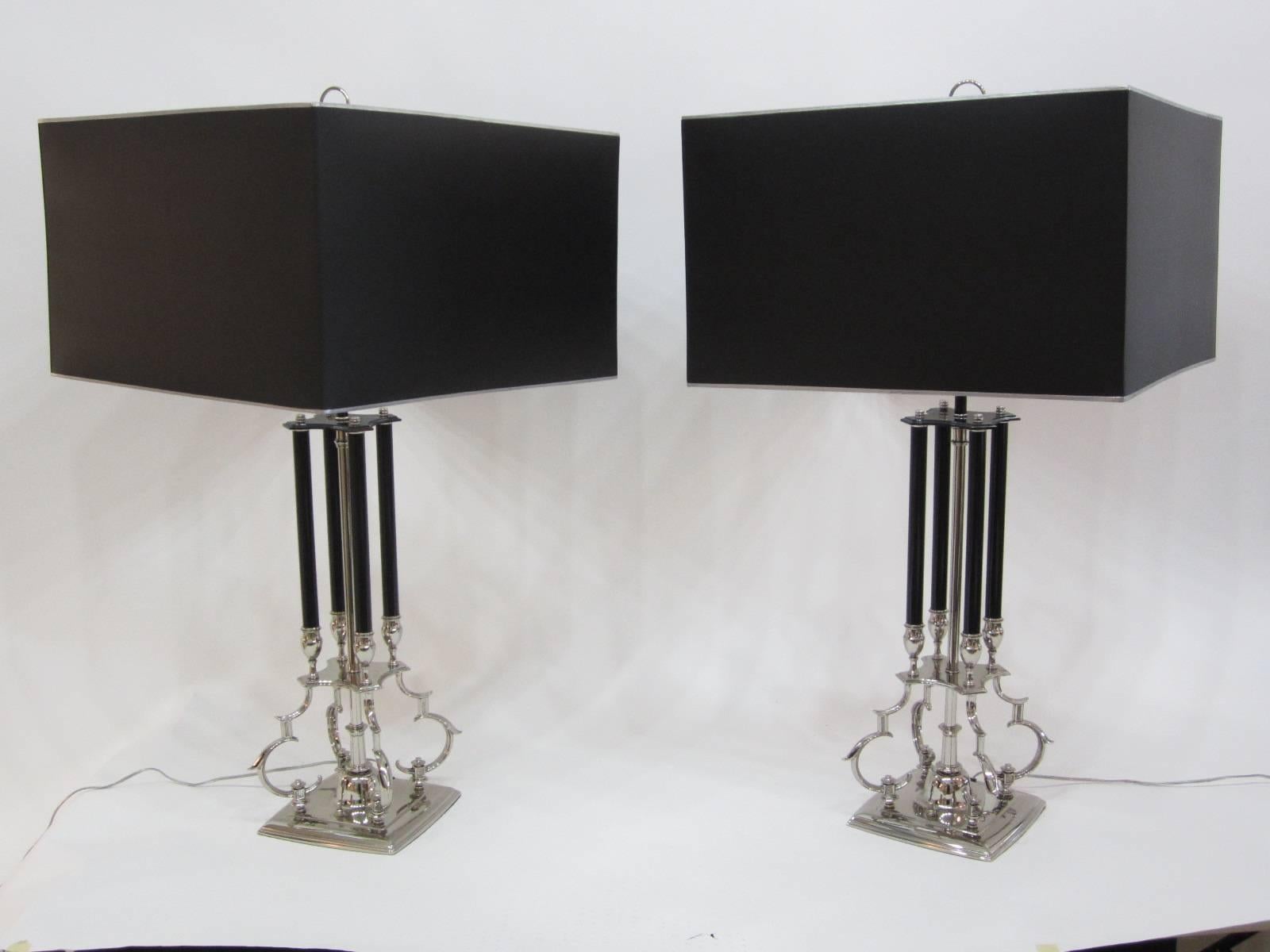 Beautiful pair of lamps with scrolled chromed bases that hold four black painted metal columns. Double sockets on each lamp have been newly replaced and the lamps have been professionally appointed and rewired. Chrome hoop finials finish off these