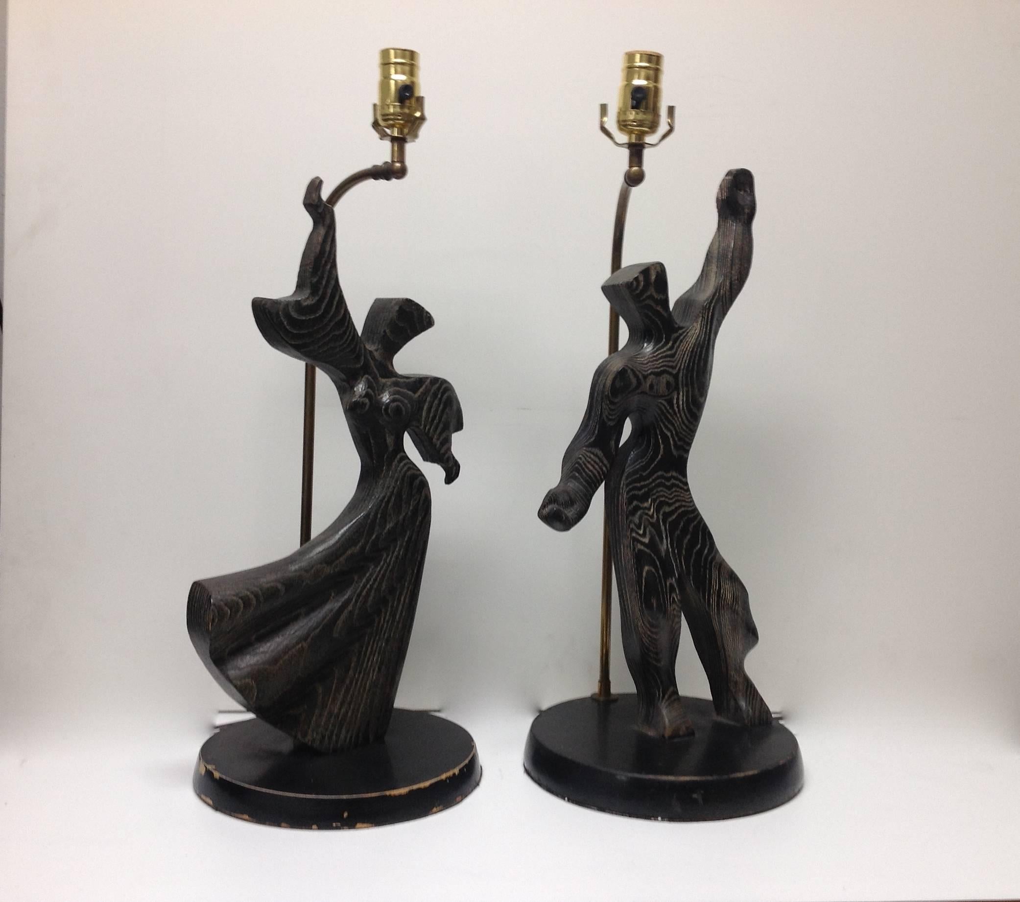 Fantastic pair of solid oak male/ female lamps in a cerused finish. Wonderful and fluid in their movement, these lamps are mounted on round black painted wood bases which show natural wear. Original working condition, lamps have not been altered.