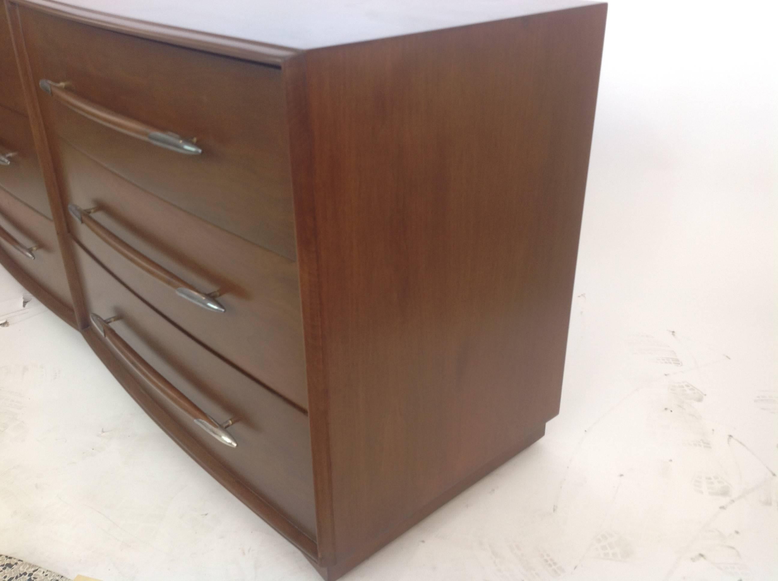 Fantastic side by side dresser or chest of drawers fashioned in mahogany with the same mahogany linear drawer pulls which terminate with metal atomic tips. Top drawers are galleried and interior is very clean, this dresser was refinished perfectly