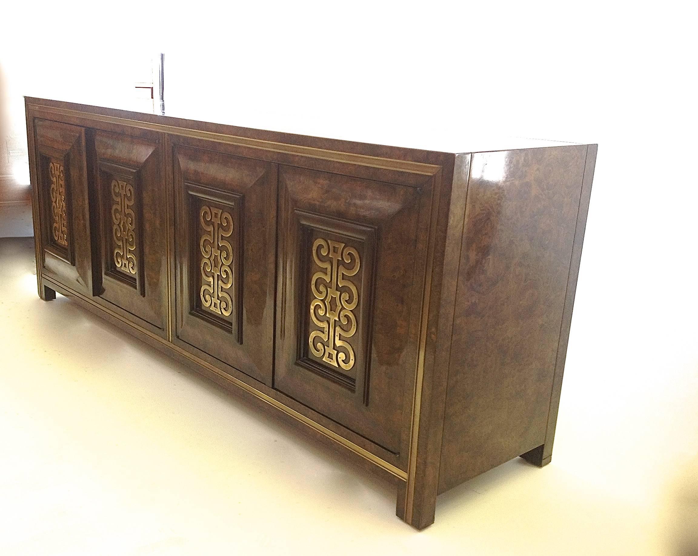 Fabulous credenza, sideboard or buffet in burl with brass adornments on door panels and on frame. Left side reveals drawers behind doors and right side reveals two shelves behind doors. Natural wear with minor touchups on side near bottom.