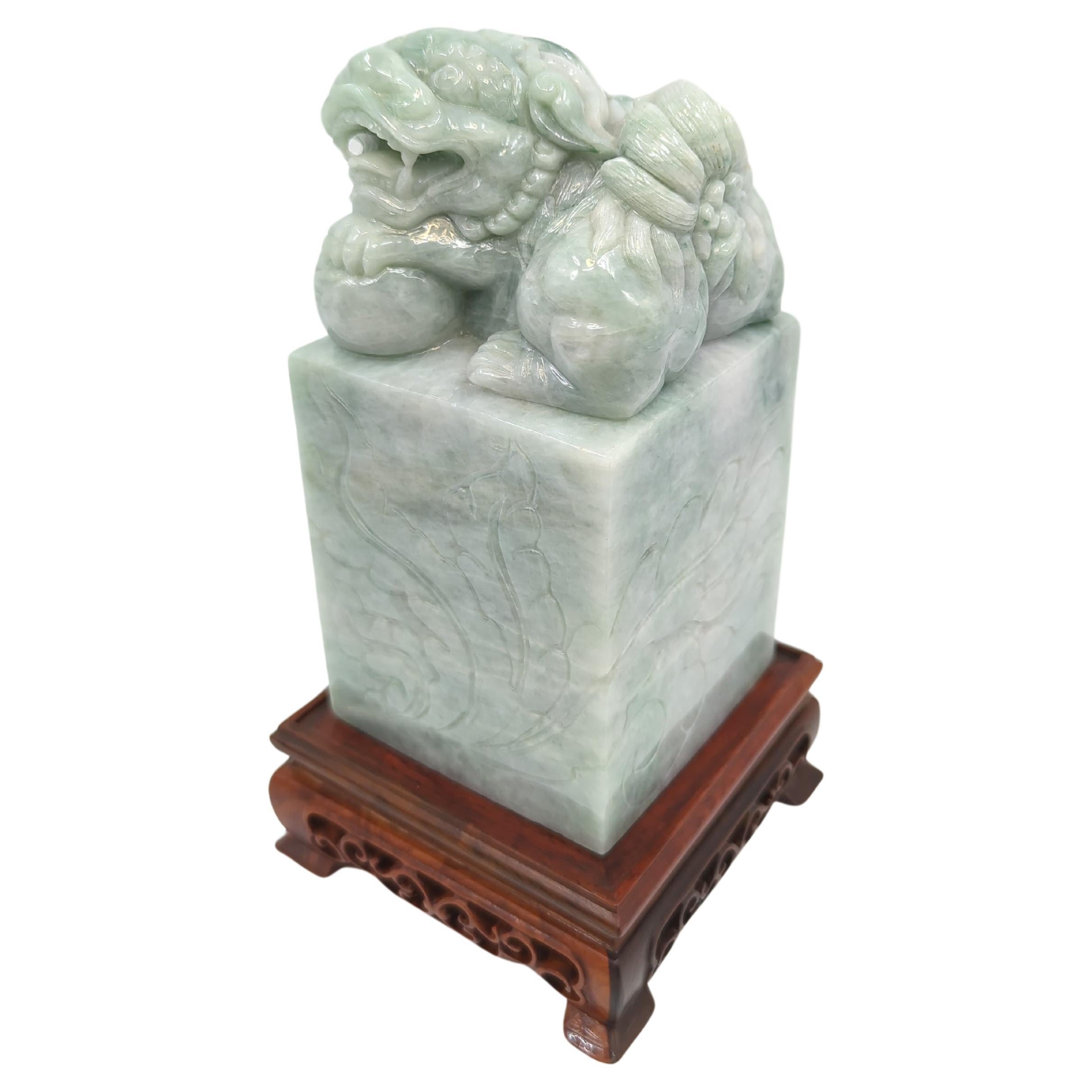 This modern Chinese jadeite seal stone, standing at an impressive 8 inches on its stand, is a remarkable piece of artistry, showcasing the exquisite craftsmanship associated with contemporary Chinese jade carving. Carved on a square base, the seal