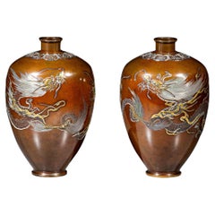A pair of bronze vases depicting two dragons marked Nogawa Company
