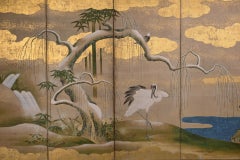 A six-panel folding screen from the Kano School, gilded with gold leaf, depicting a pair of red crows