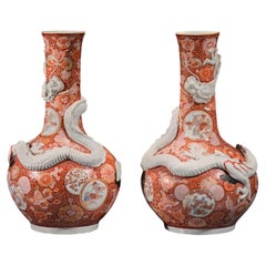 A pair of Imari vases with relief dragons, signed Hichozan