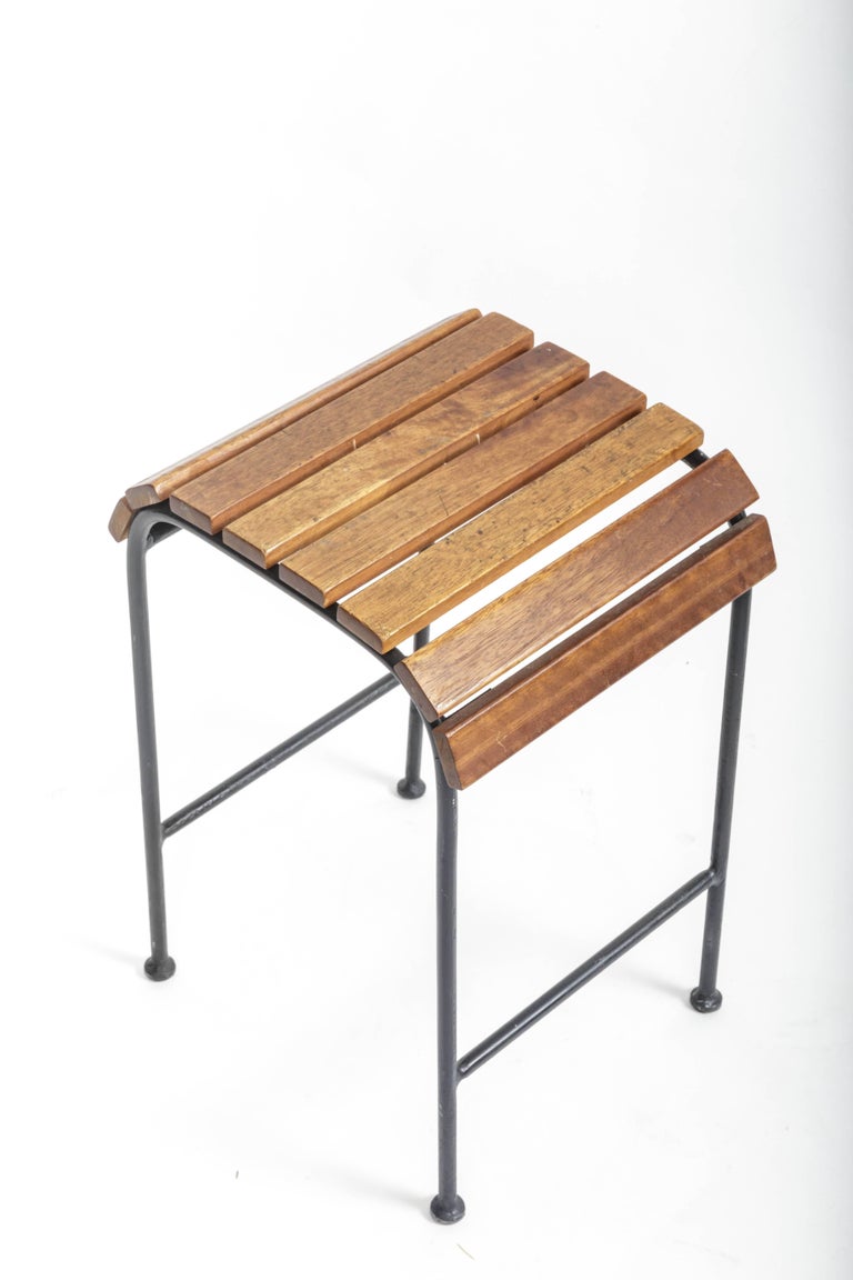 Vintage slatted wood and metal stool, France, 20th century.

Smart design consists of a tubular metal frame, comfortable foot rests, and a slatted wood seat that wraps over the edge on both sides.