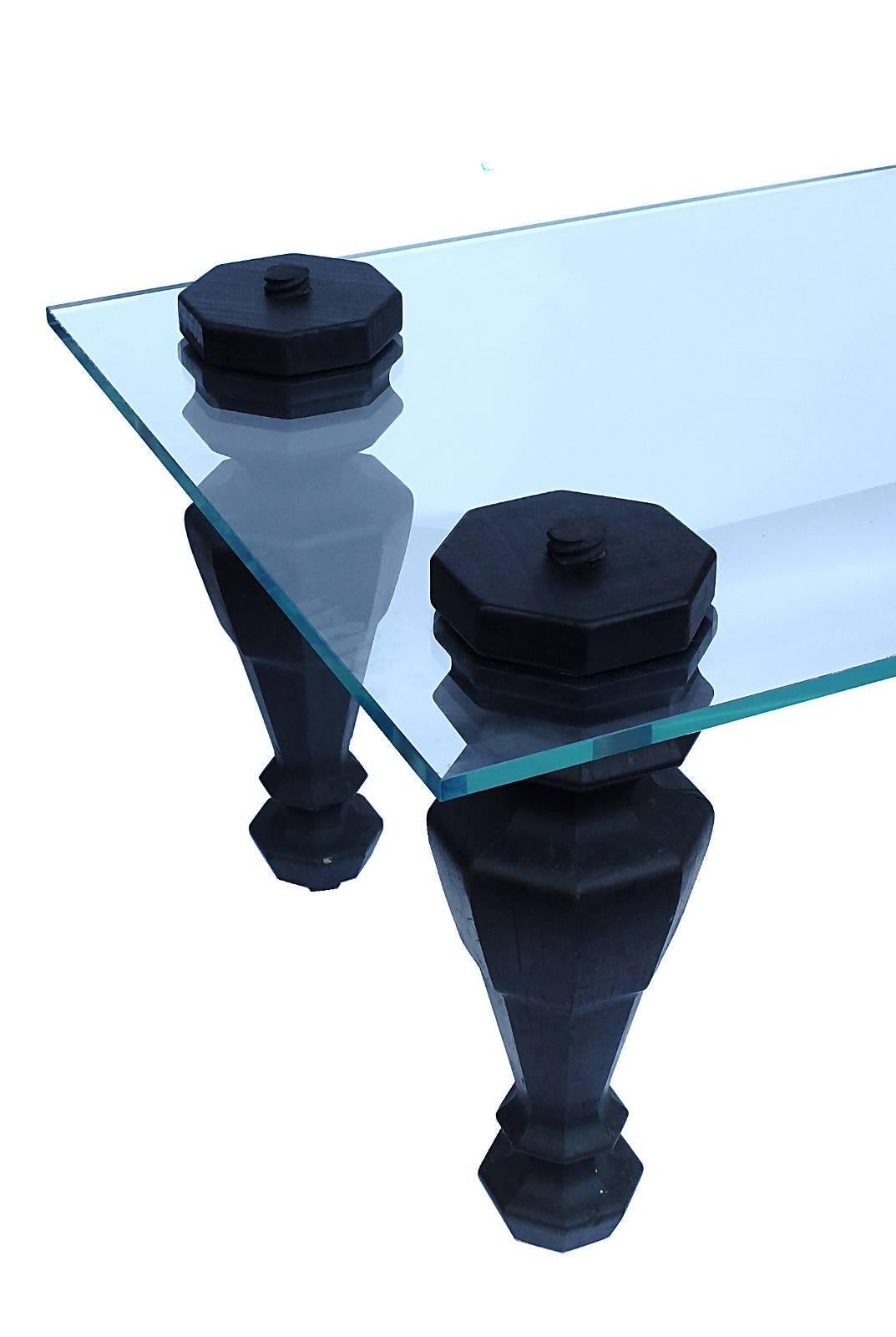 A fine example of reinterpretation and reutilization of an antique elements A four wooden grande piano legs with wheels have been reused as a big rectangular coffee table with a glass top.