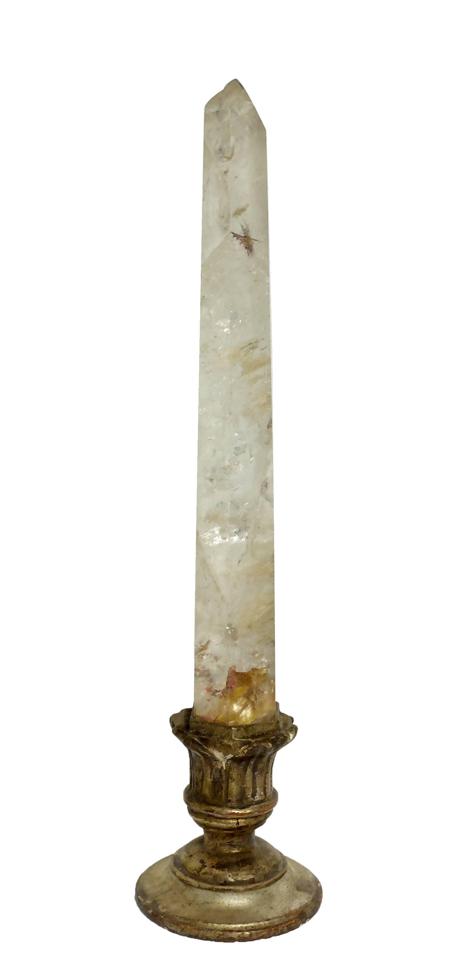 A rare Wunderkammer Naturalia specimen, a single rock crystal monolith obelisk shaped, mounted over a gilded wooden base win engraved leaves decoration.