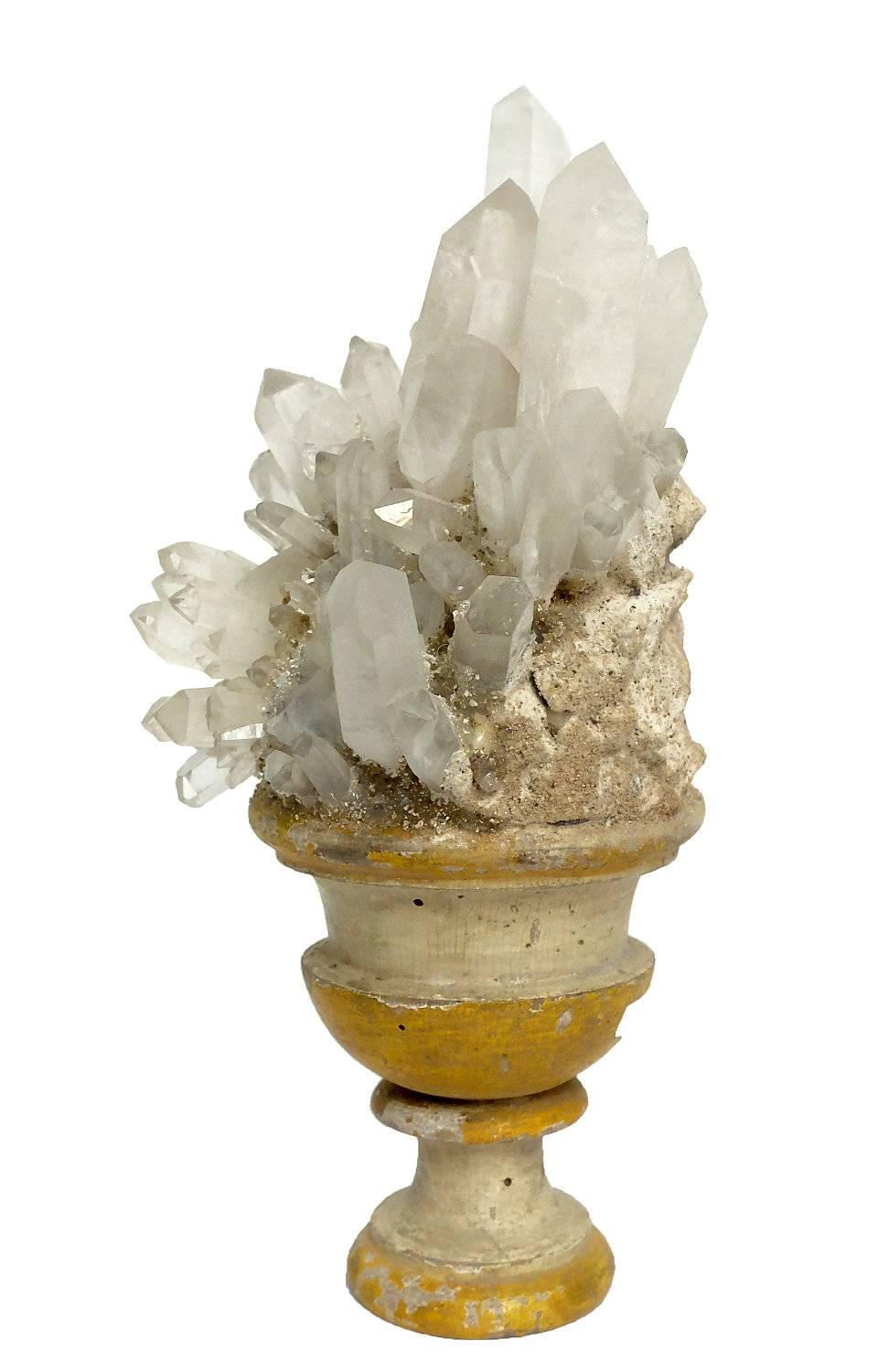 A naturalia mineral specimen a rock crystals druze, mounted over a white and yellow lacquered wooden base in a shape of a vase.