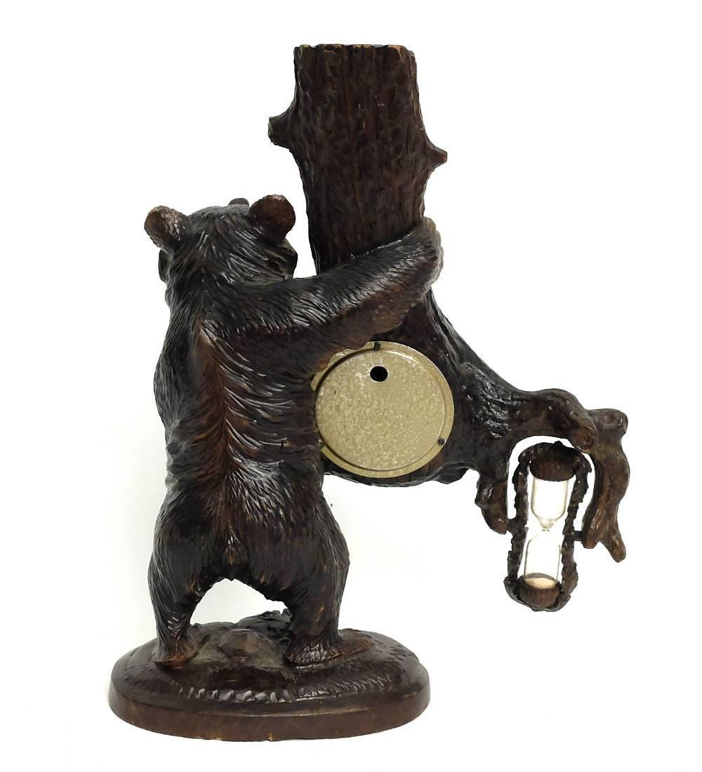 Black Forest wooden carved bear depicting a bear standing over a grass field and holding a huge branch into which are set a thermometer, an English barometer and an hourglass. Excellent carving, Black Forest, circa 1900.