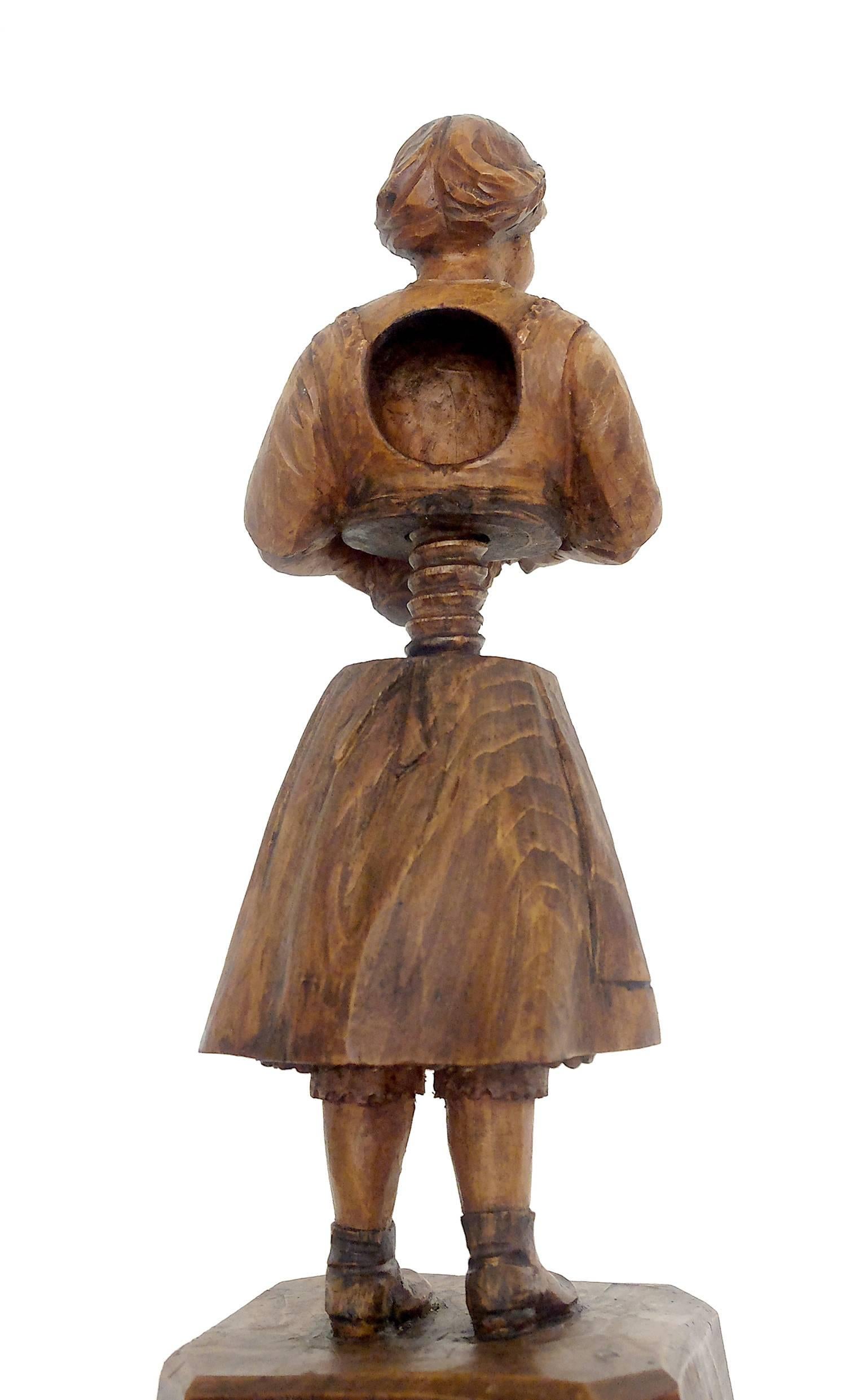 The nutcracker is sculpted and carved out of fruitwood and depicts a charming, smiling young girl holding a floral basket, Tyrol, circa 1880.

 