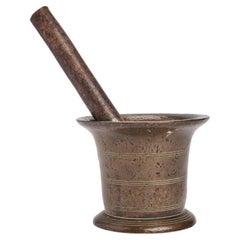 A bronze apothecary mortar with incised lines & iron pestle. Italy 18th century.