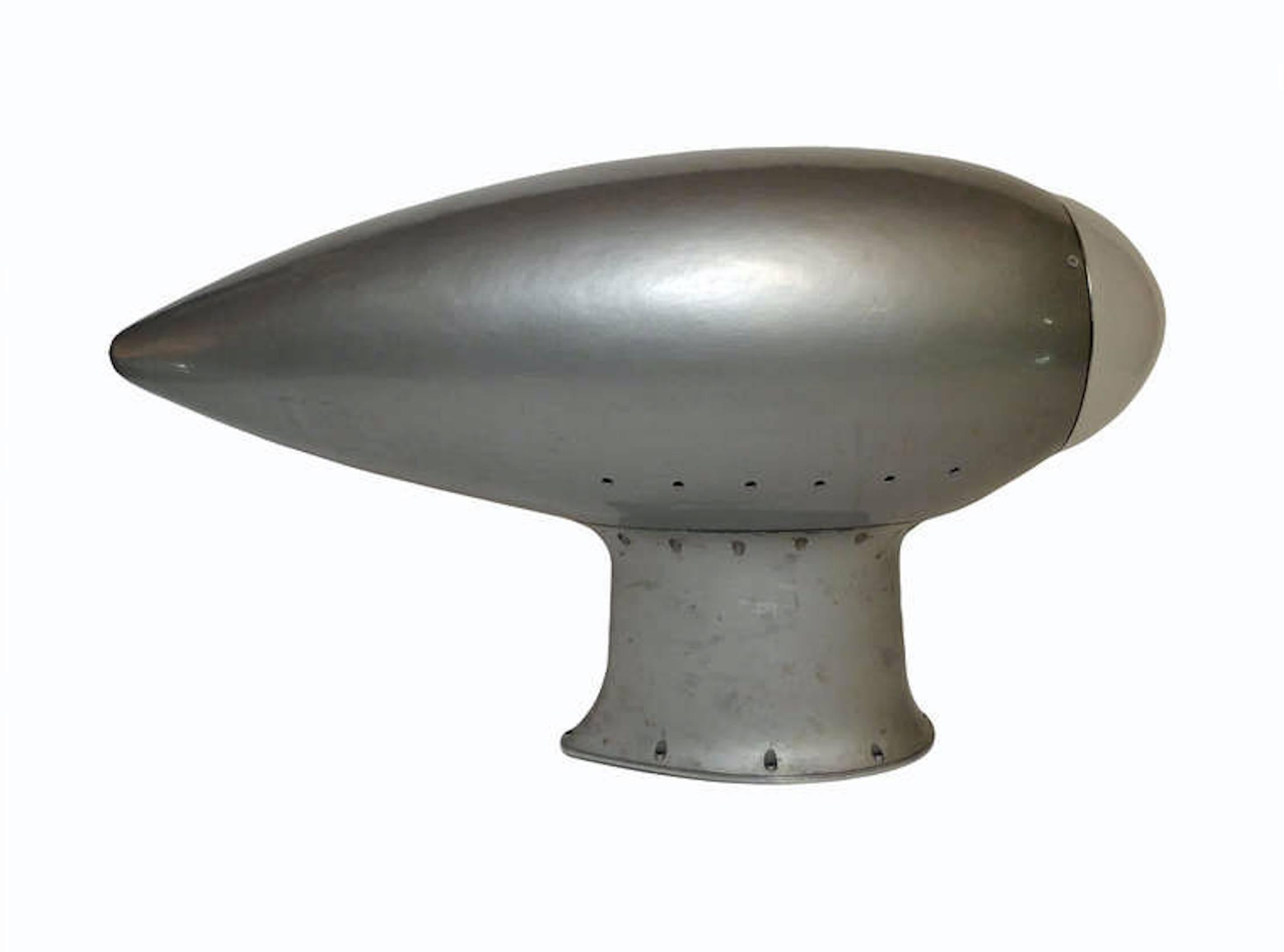 A fine example of reinterpretation and realization from an old element. One radar cover from an American airplane have been reused as a sconce . The structure is made out of painted wood , gray color, with the top element made out of curve frosted