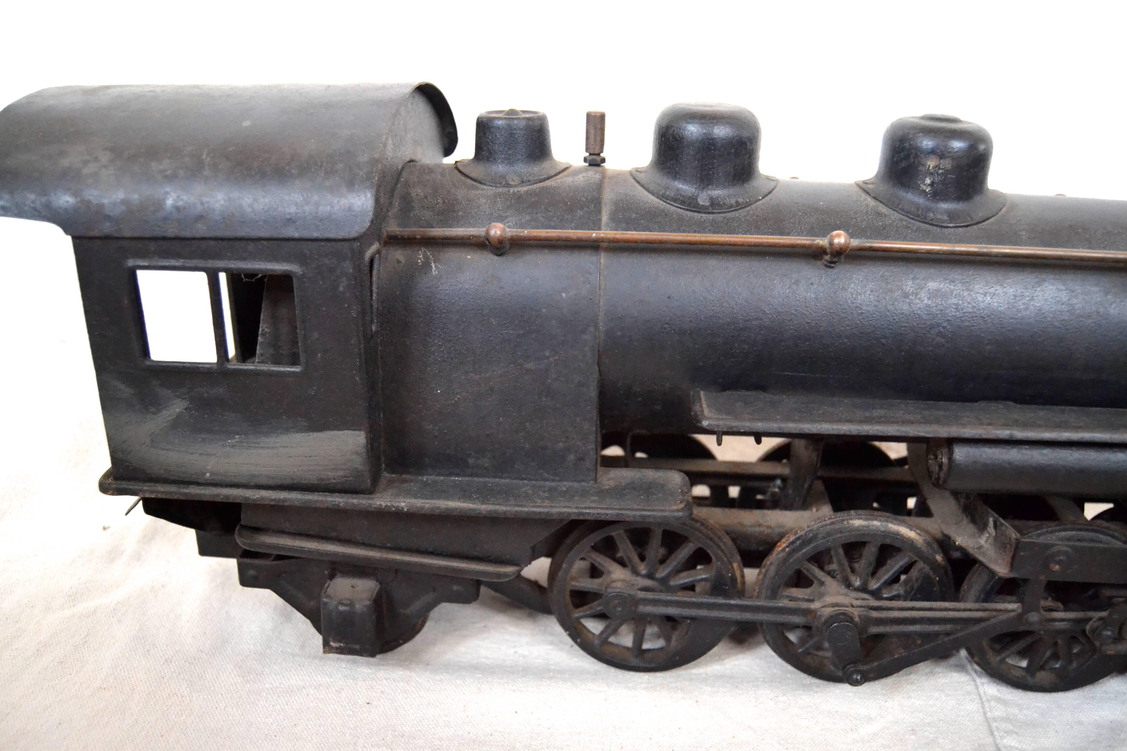 Large iron model of a Victorian Locomotive crafted of sheet iron with cast iron details such as the working wheels. Sculptural model made with an impressive restraint of detail resulting in a strong Folk Art statement. Great old black painted