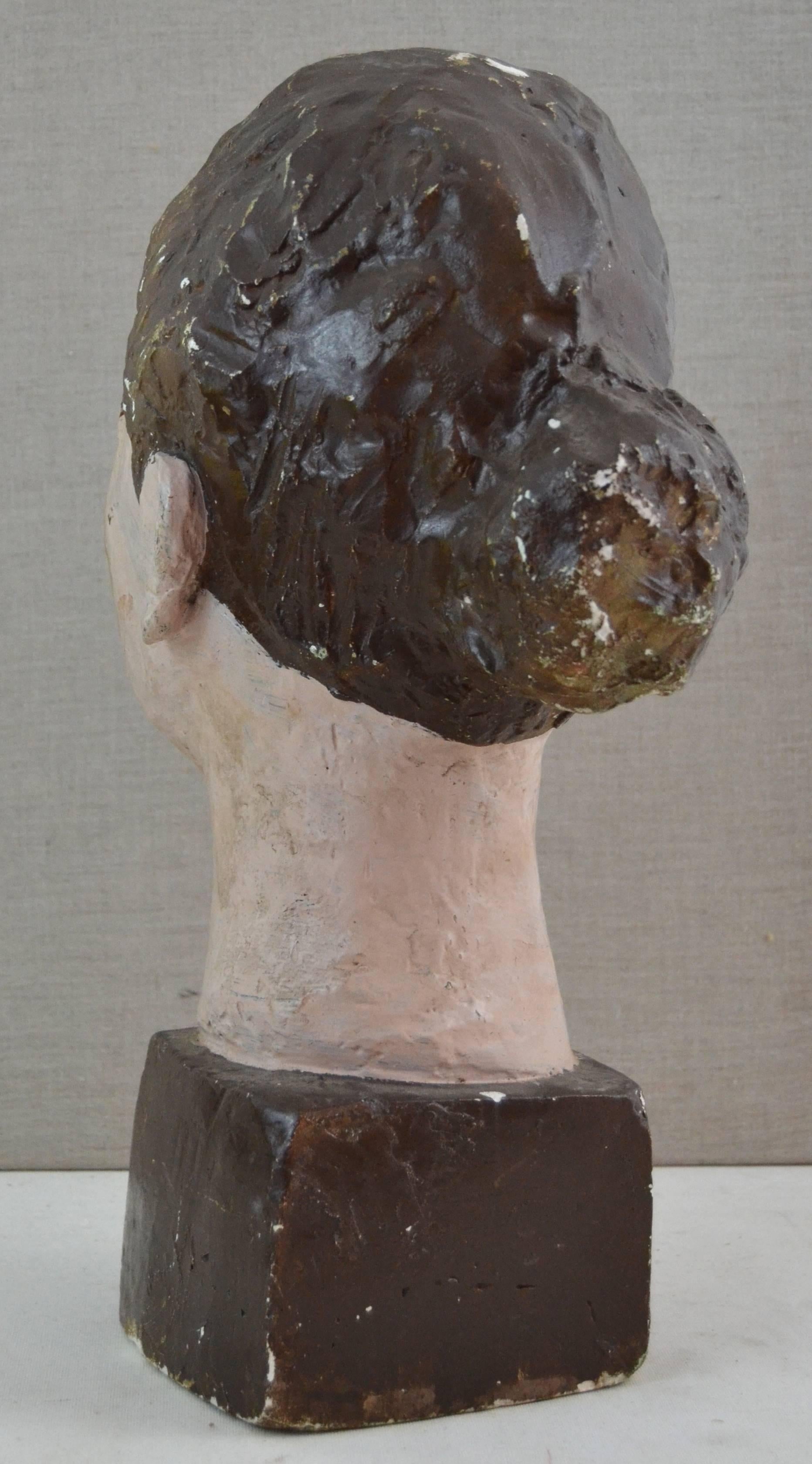 Sculpted and polychrome plaster bust of woman dating from the 1920s. Wonderful surface and particularly strong sculptural and graphic presence. Unknown artist and origin. Some paint loss and a repaired chip to front corner, neither a distraction.