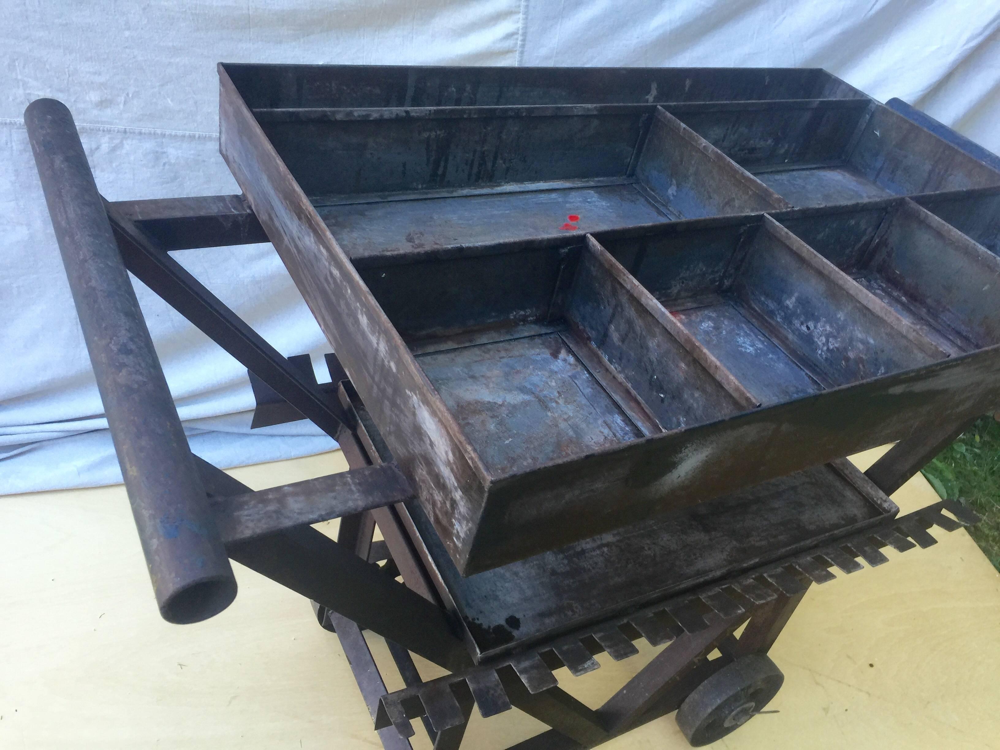 Funky and sculptural iron cart with great function and form. All hand-forged except for the manufactured wheels. Script lettering show the origin as triangle metals. Large sectioned top and lower tray make a quirky and useful bar cart or display,