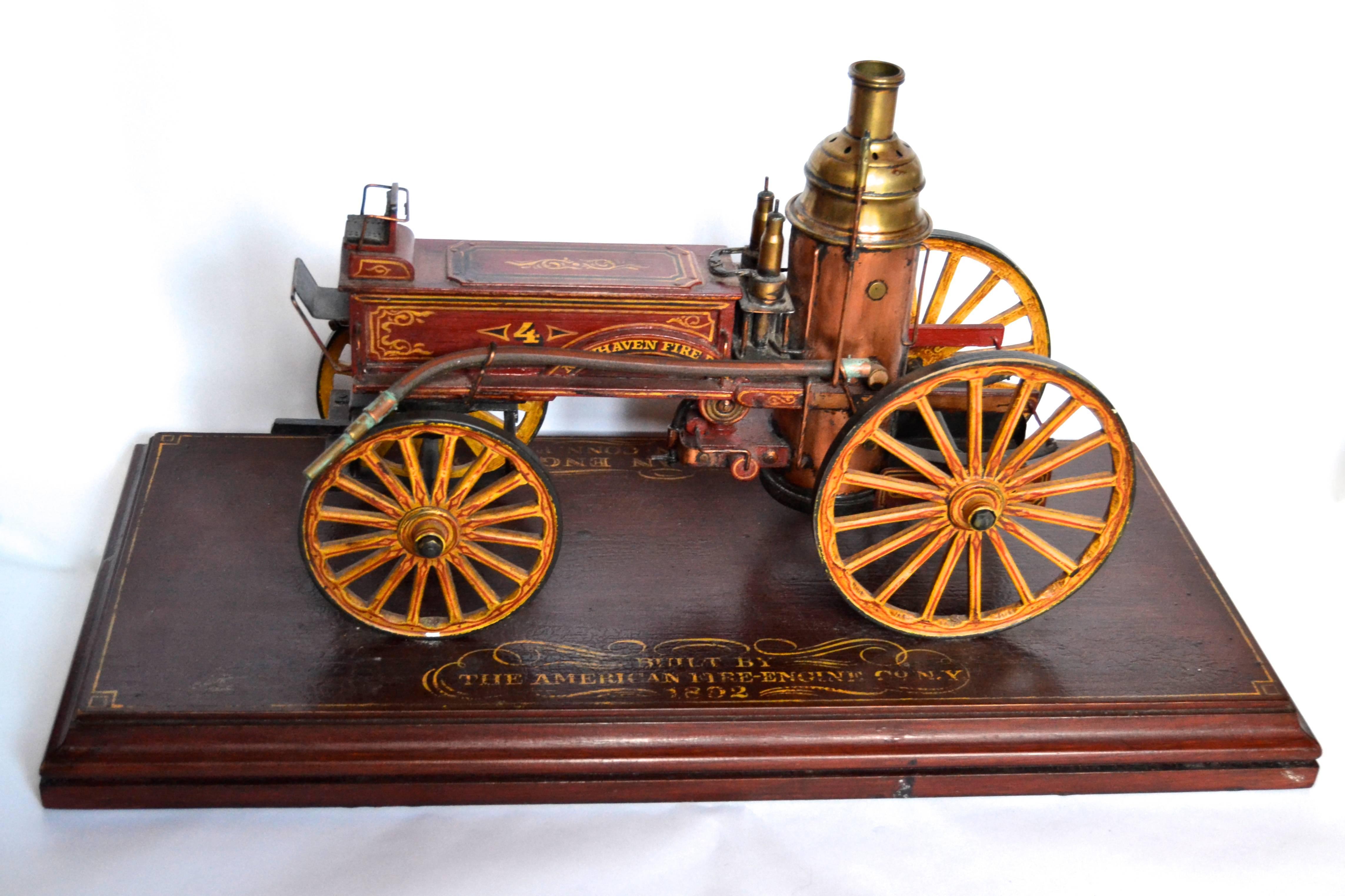 Elaborately detailed handcrafted model of a firefighting Apparatus identified as 
"Columbian Engine New Haven CT F.D...Built by the American Fire Engine Co NY 1892". Lovingly constructed of polychromed wood, copper, steel and leather for
