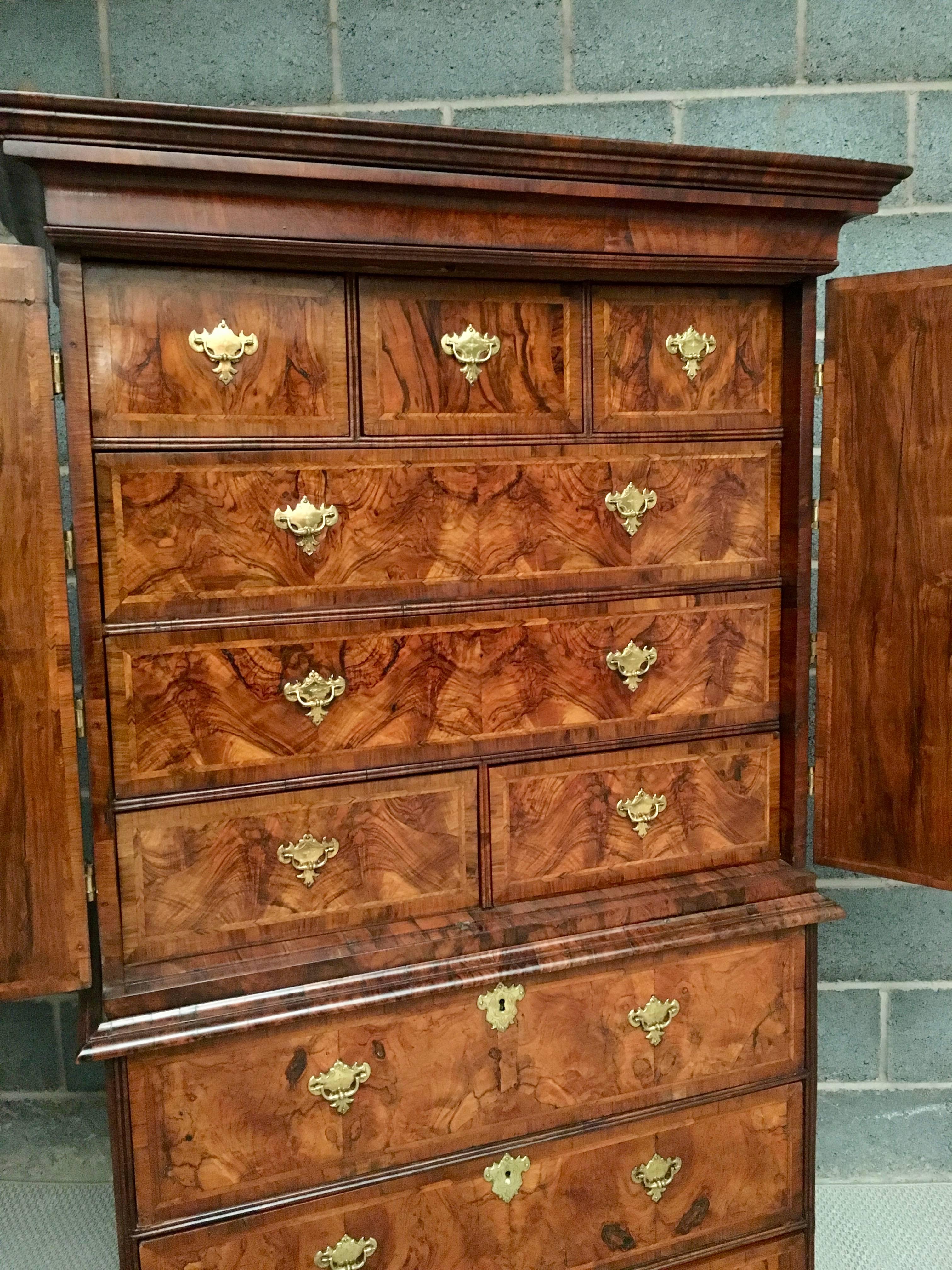 An early 18th century walnut fitted two-door cabinet on chest retaining the original handles and hinges. The metal work with engraved details.
Good mellow color and patination.