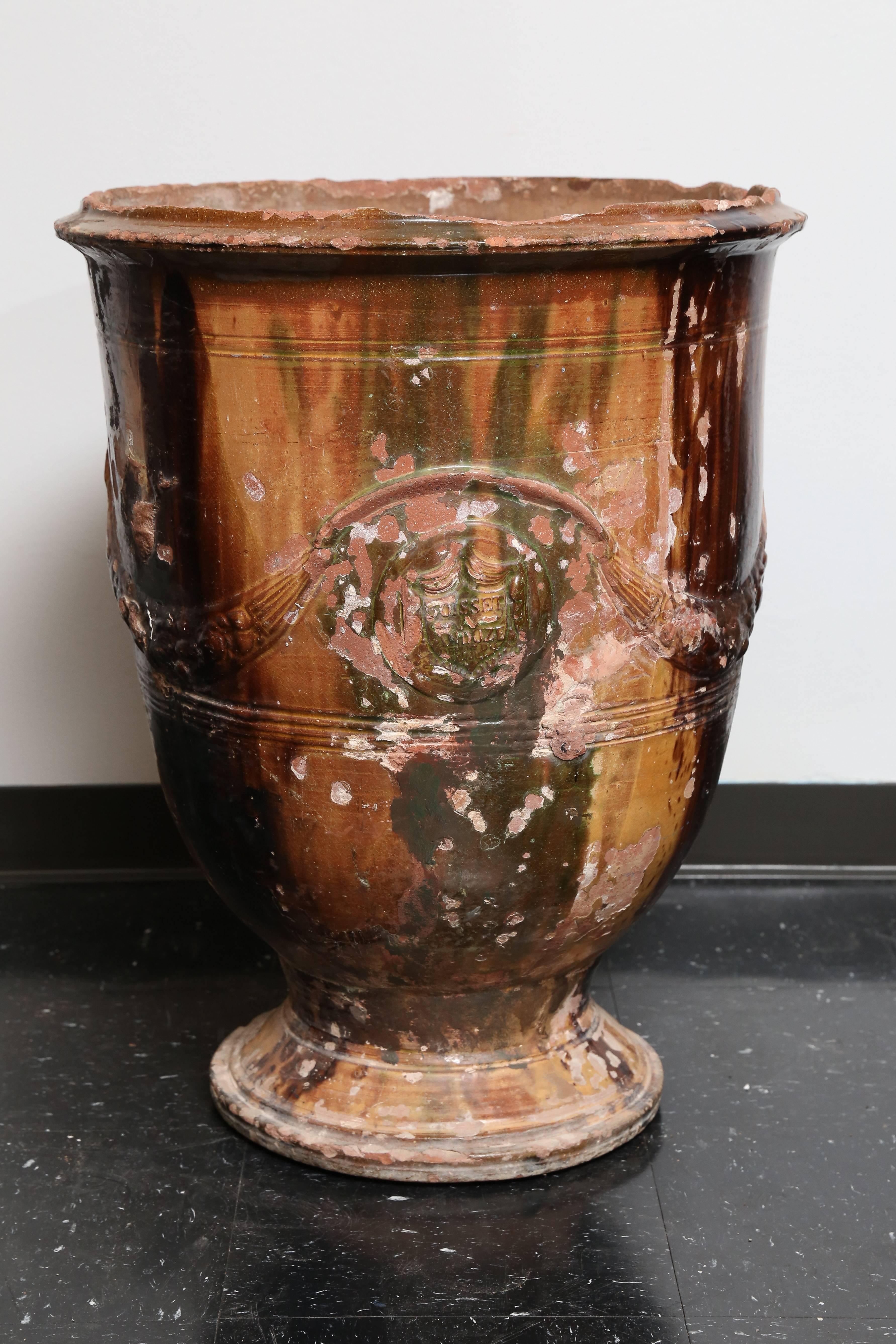 Anduze vase in very good condition; some chipping at base and rim consistent with age and use; deep brown and green drip glaze; attractive swag decoration, with maker's mark 