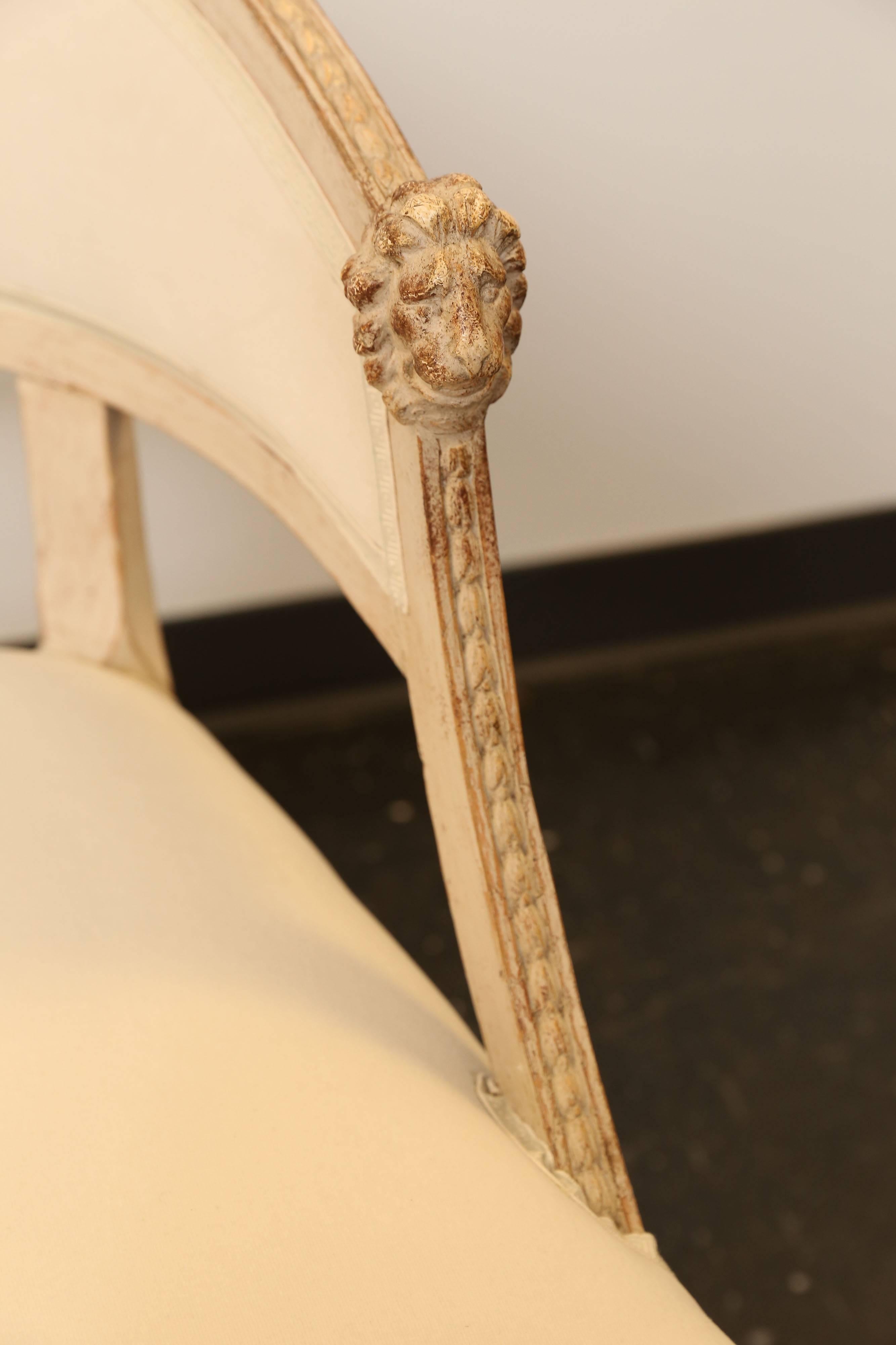 Pair of 19th century Gustavian barrel back chairs with lion's head at ends. Original paint with scraped finish and recently upholstered.