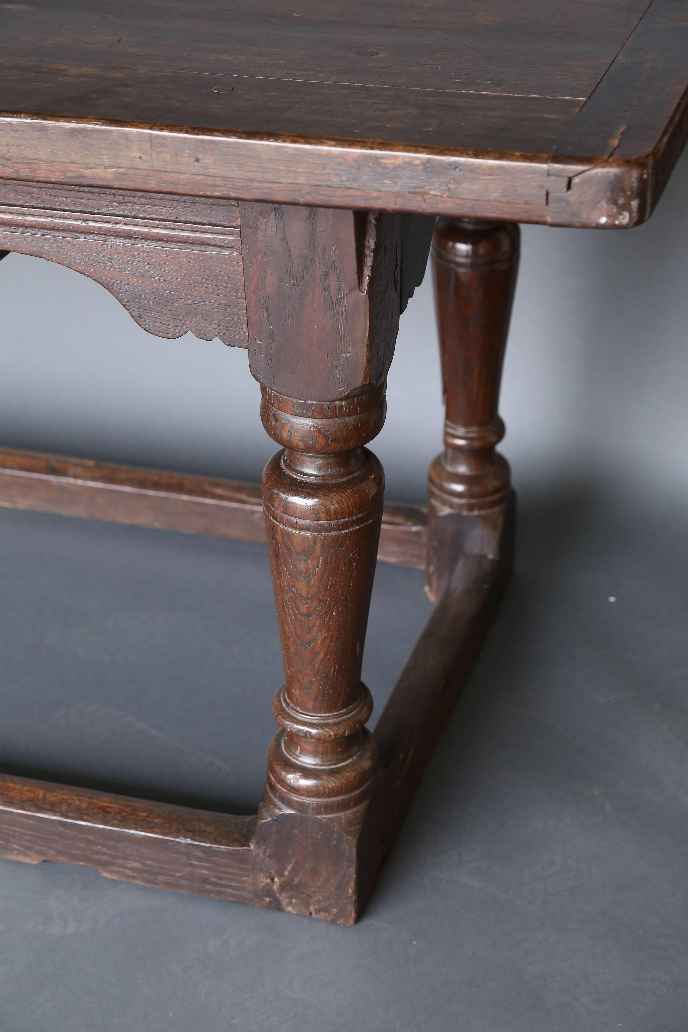 17th century and later oak refectory dining table, the cleated plank top on four baluster turned supports united by perimeter stretcher.