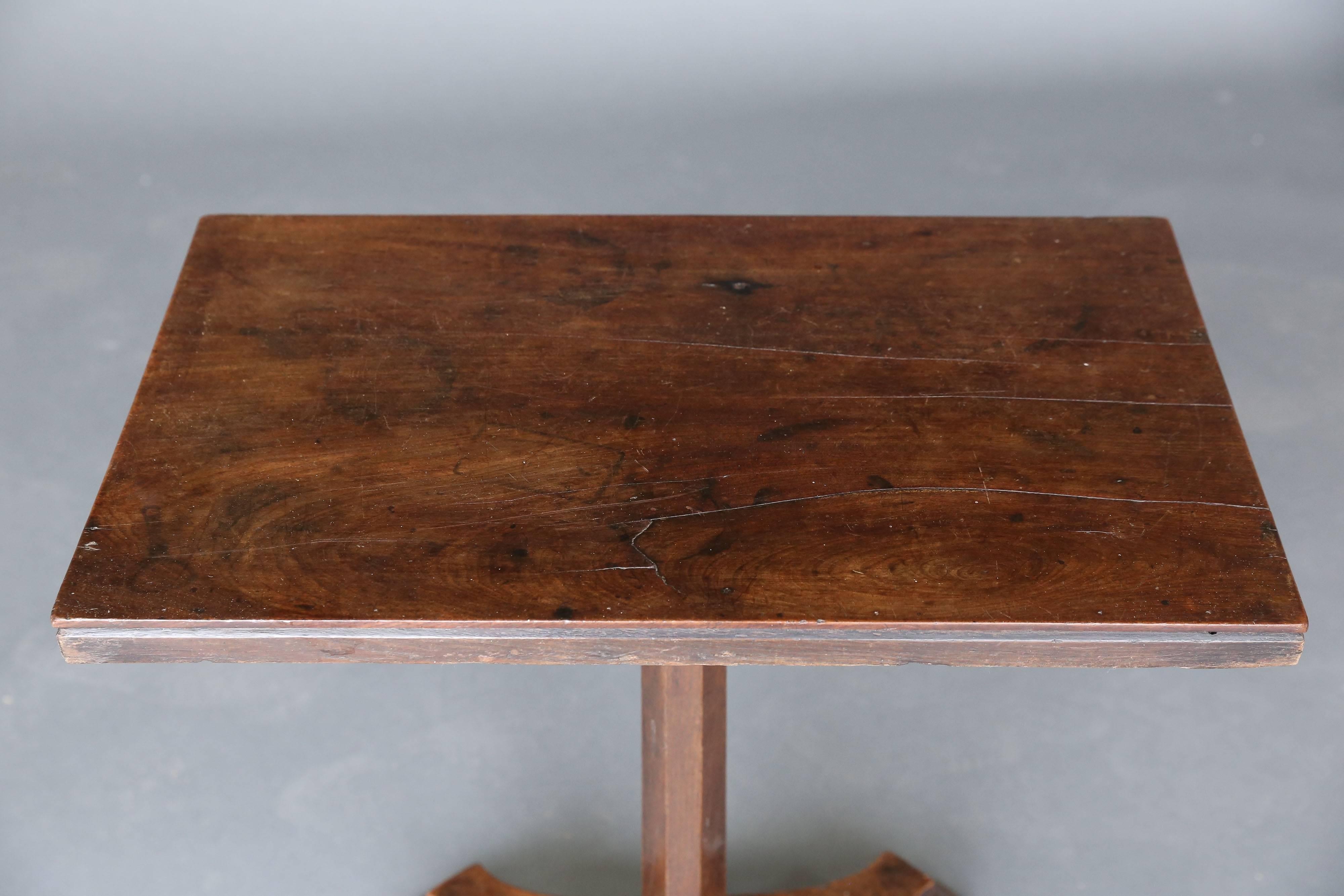 19th century narrow mahogany table with interesting base on 4 feet.
