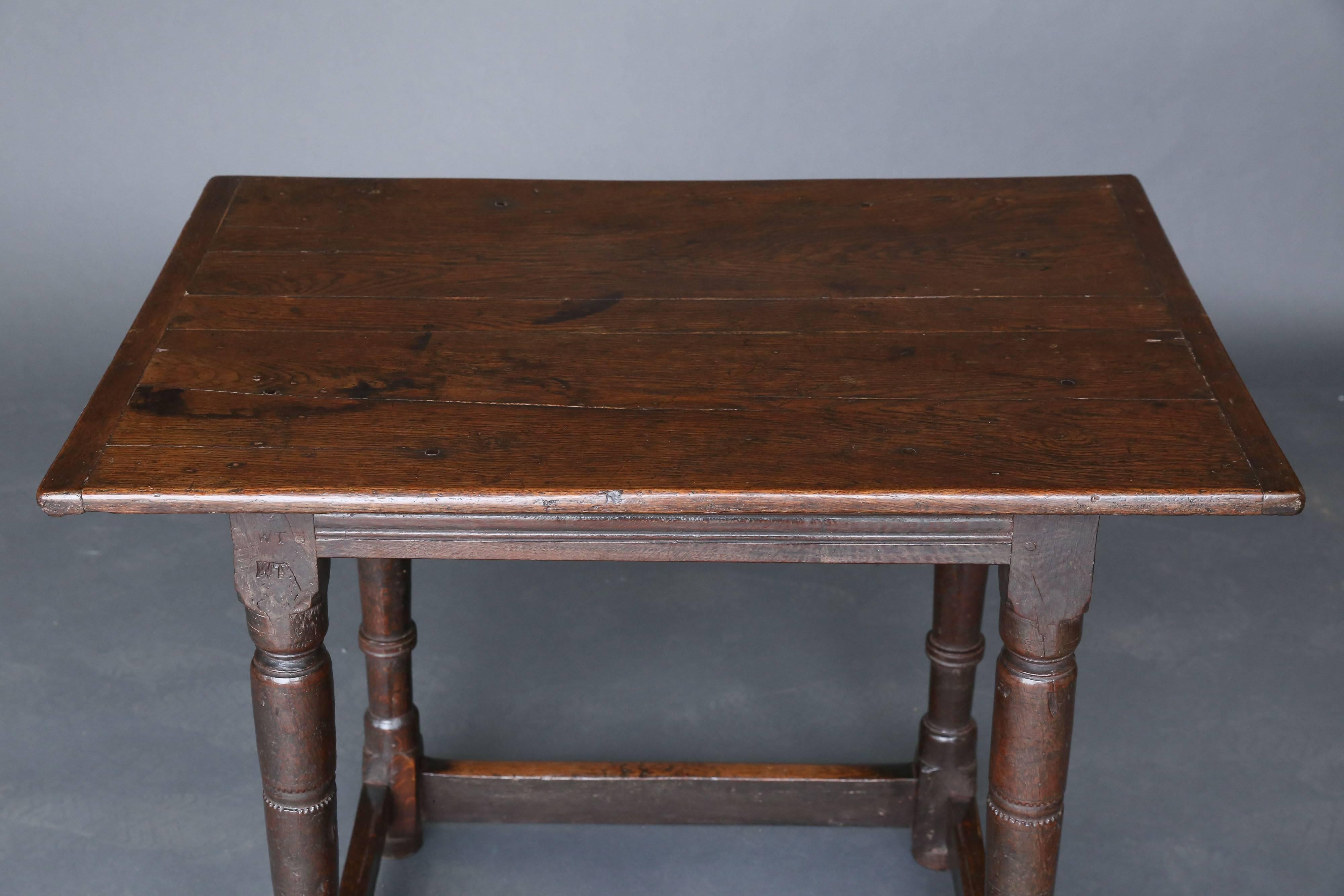 Charles II style oak side table with four turned legs and a rectangular support/stretchers around the base of the four legs.