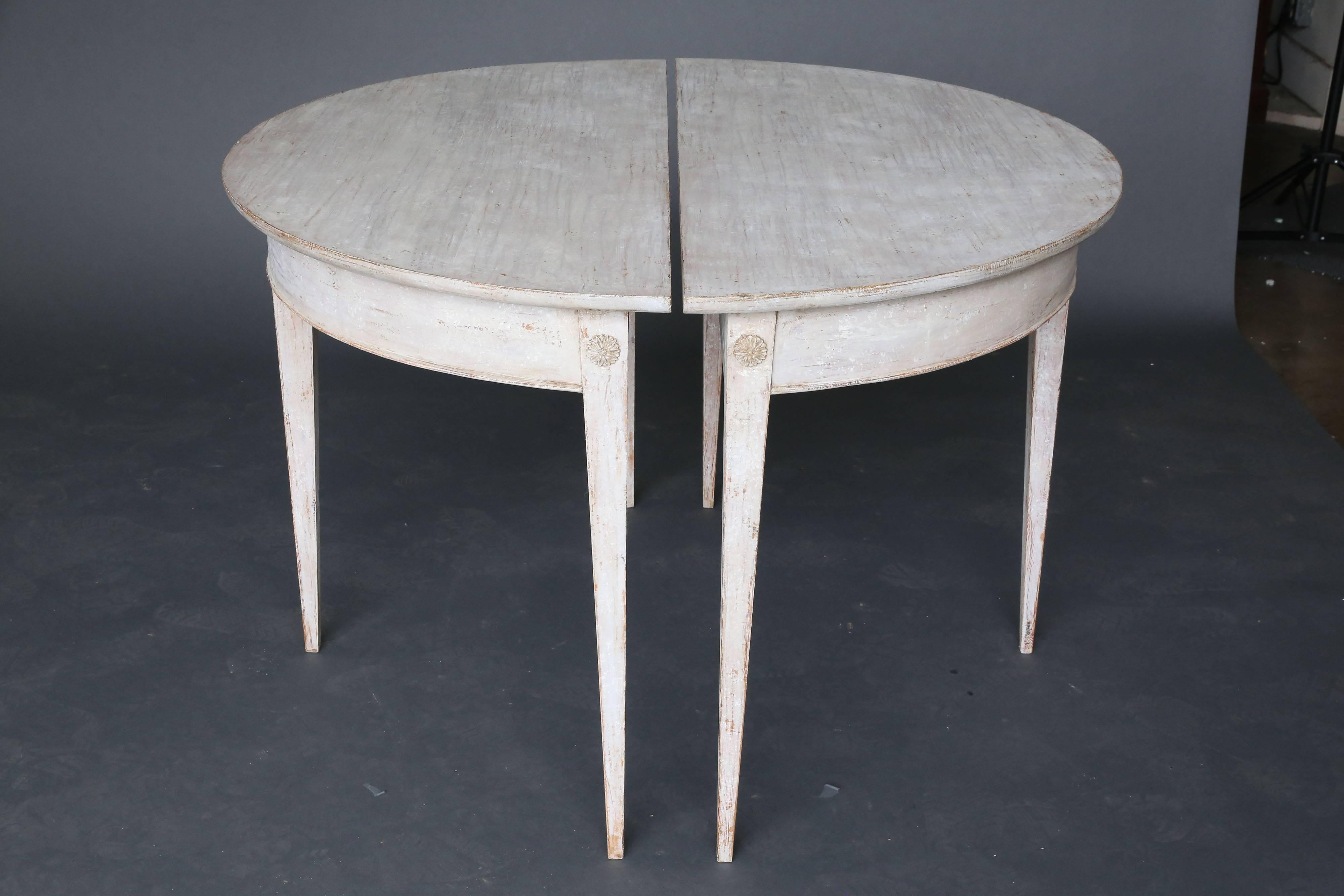 Pair of 19th century demilune Swedish tables with three medallians details on each table on three tapered legs. Beautiful patina with original paint.