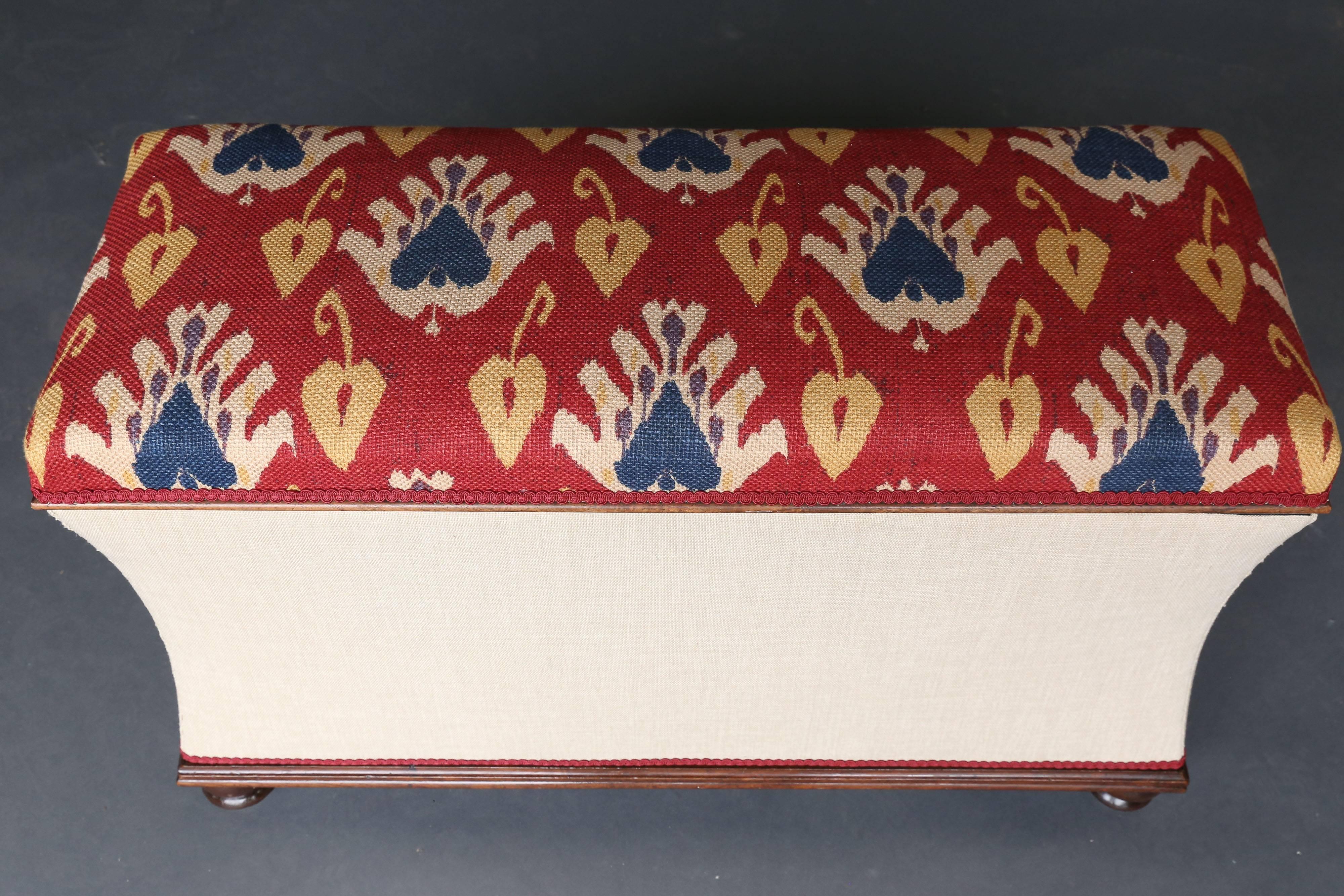 A box ottoman with mahogany bun feet. Newly upholstered but would look so much better in a single color. Great storage area within.