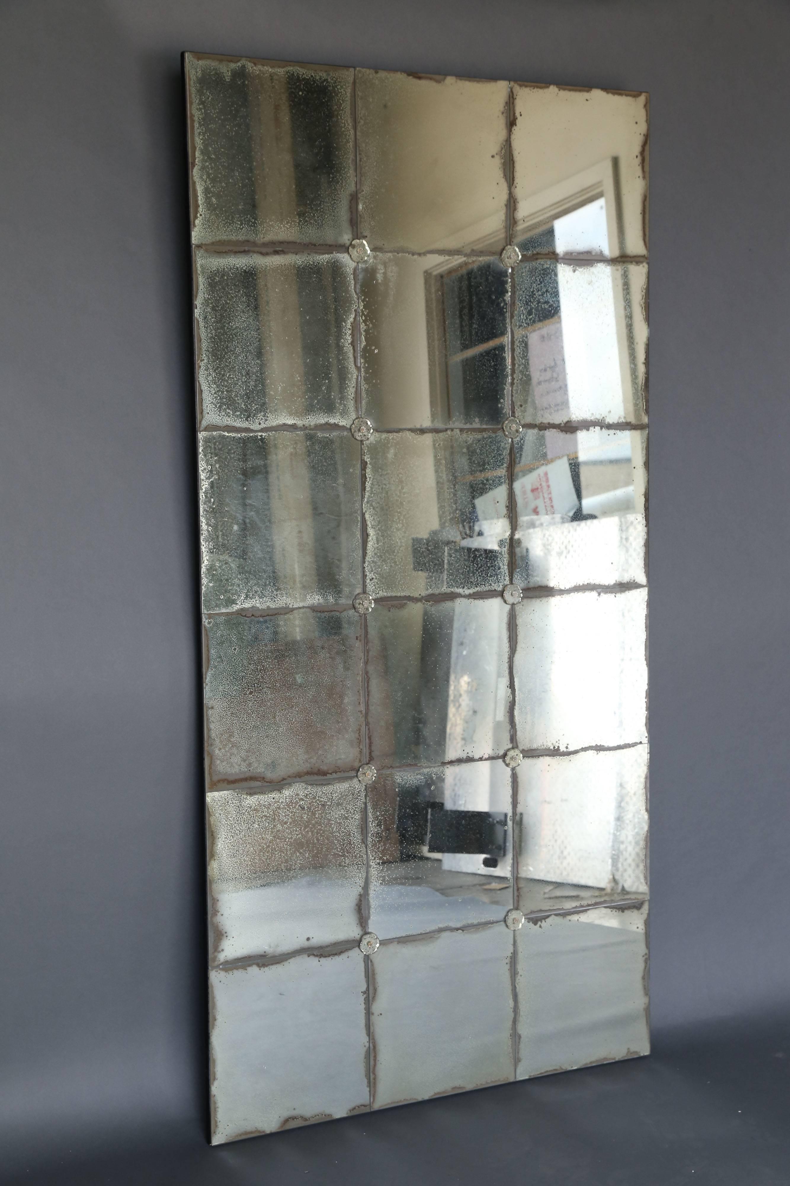 Antique 18th century mirror made of squares from various old mercury mirrors with glass rosettes in each of the four intersecting corners. Very decorative mix of antique with a modern feel.