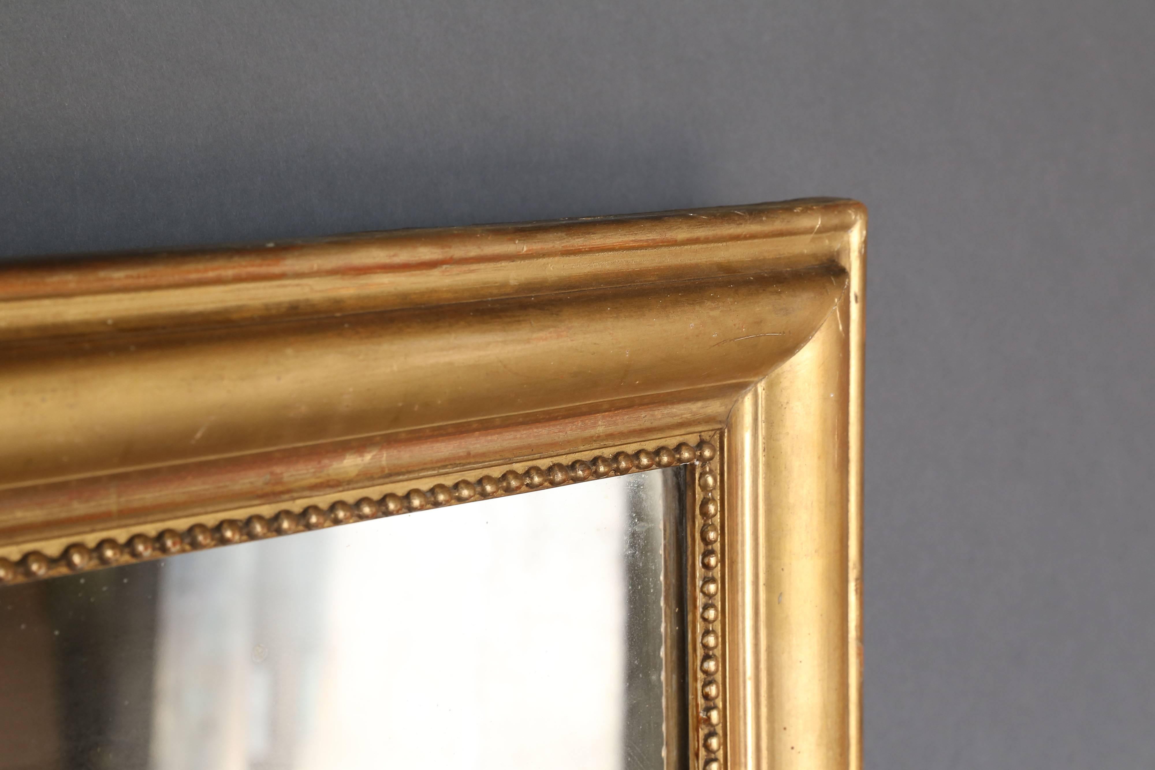 19th century French gilt mirror with pearl shaped details on three sides of the interior perimeter. Simple design, circa 1890.