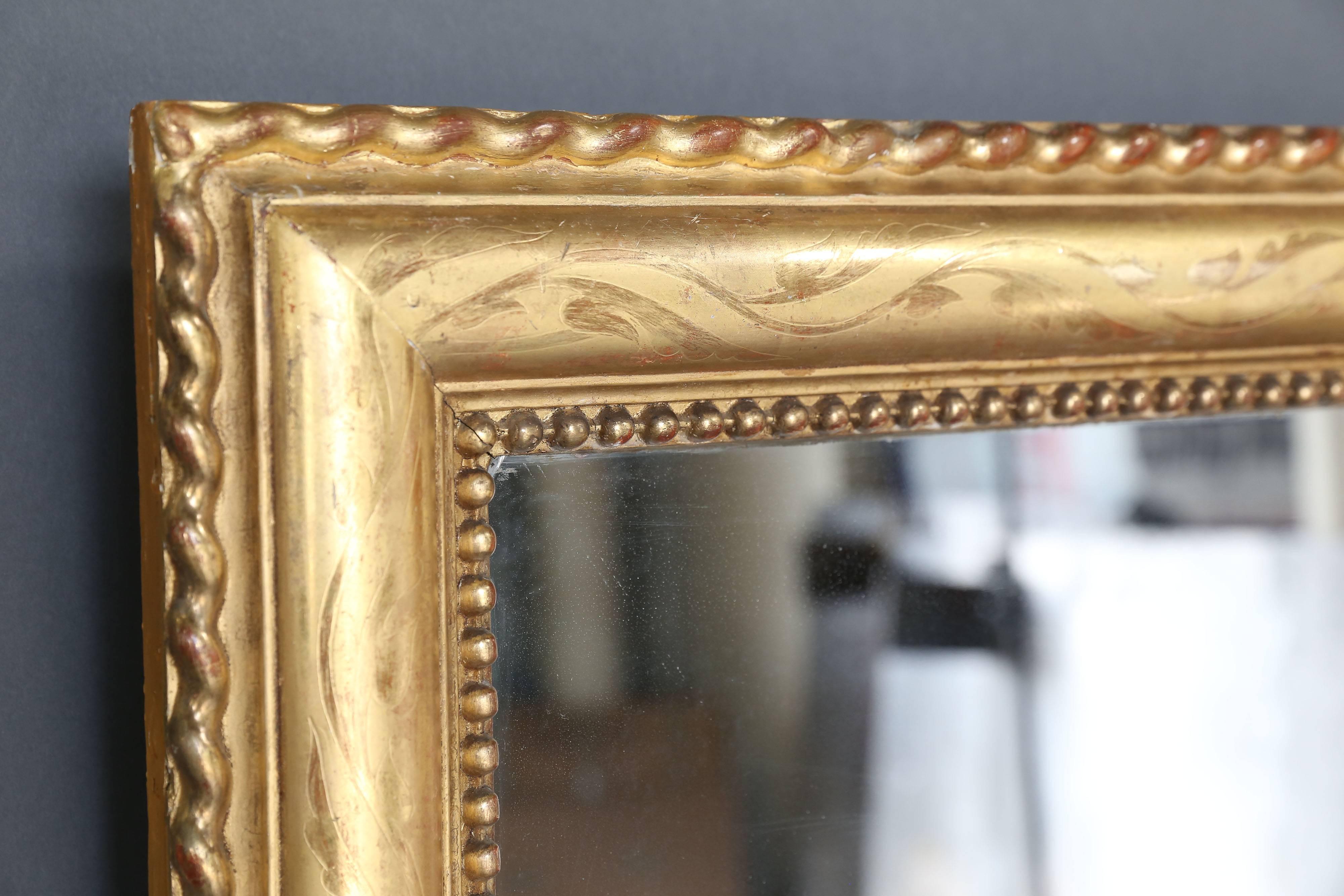 Large rectangular overmantel gilt mirror with etching and rope detail around etched perimeter. In the interior perimeter there is the pearl detail frequently seen in French mirrors of this period. Original mercury glass, circa 1870.