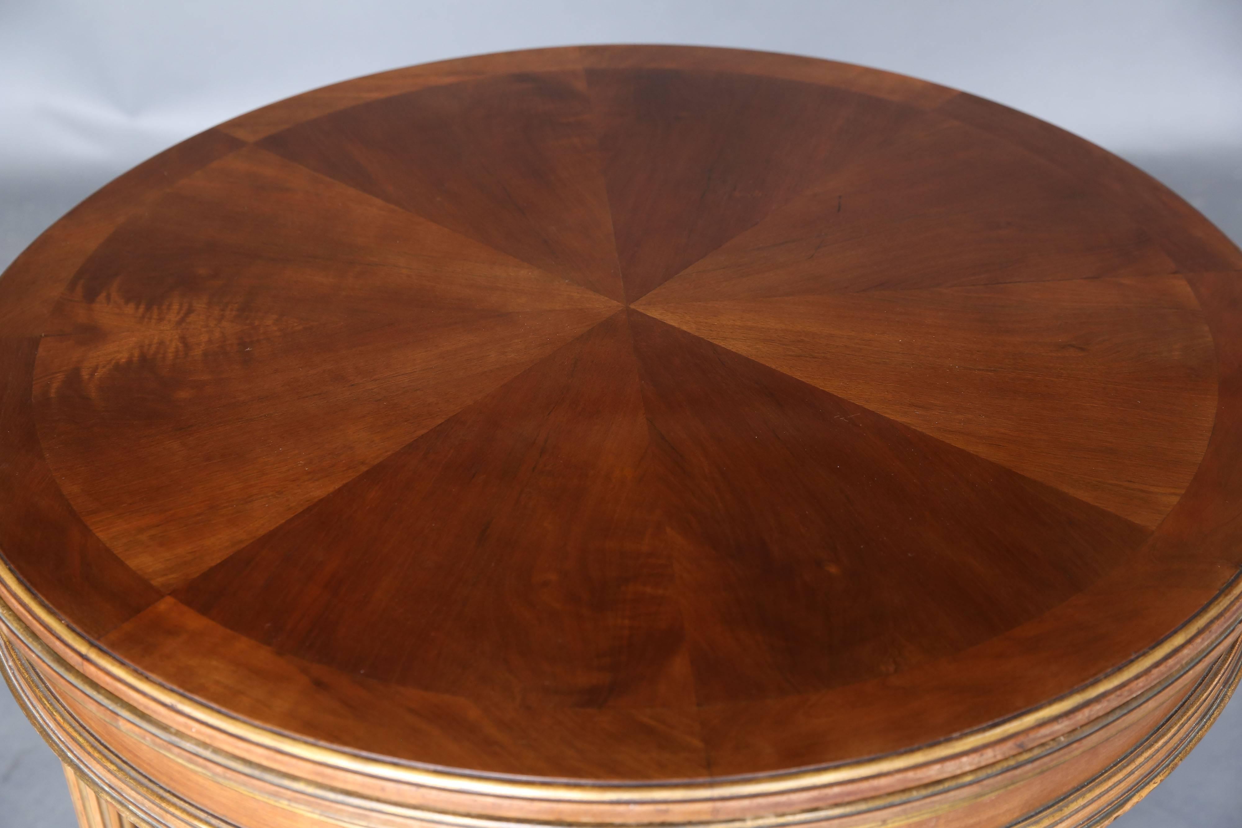 19th century French game table with flip-top that turns it into a centre table or a side table. One side of the top is in radially veneer and the other side is in leather. Table in parcel-gilt and walnut, circa 1890. Floor to skirt of table: 24.75