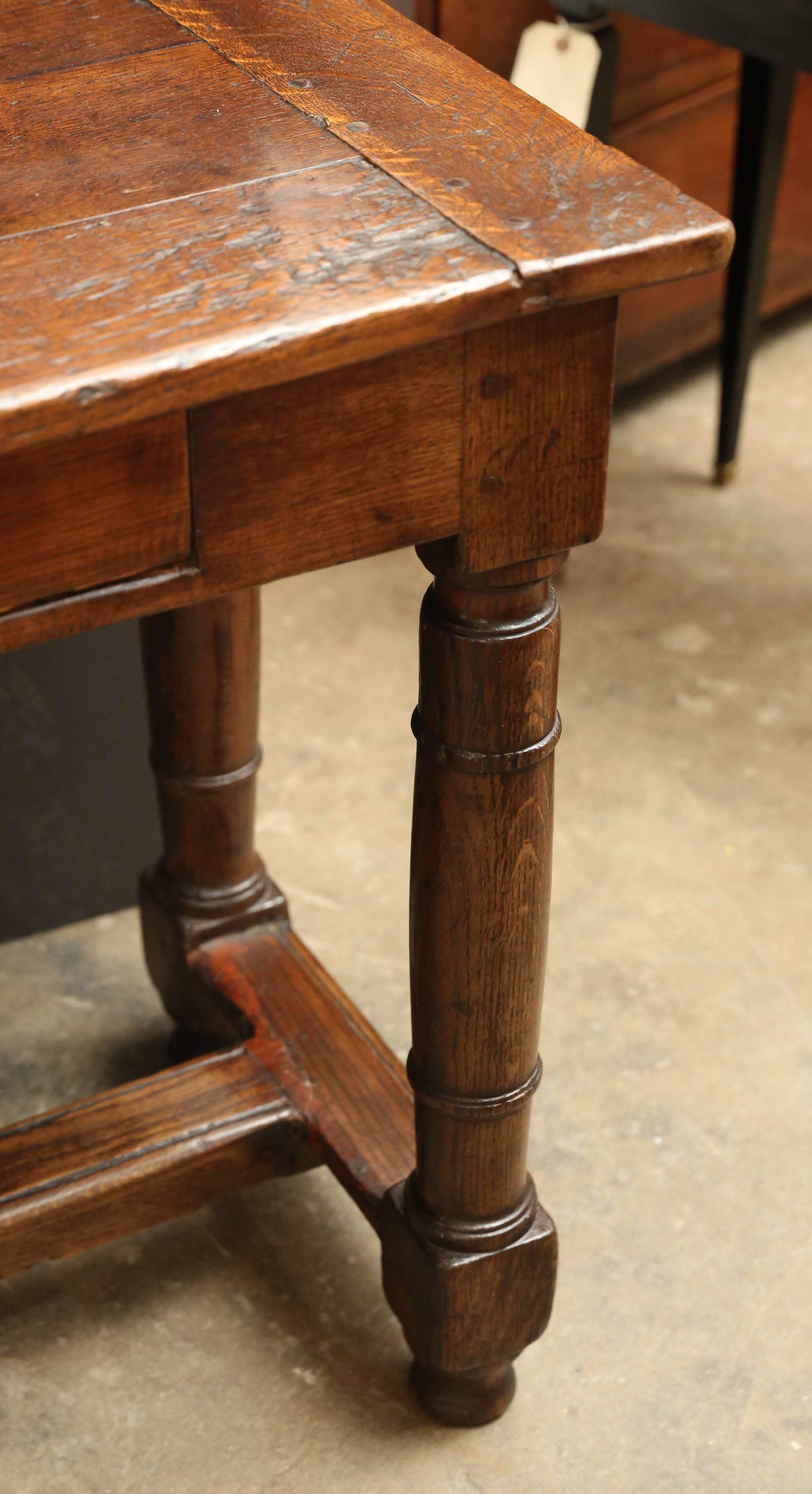 19th century narrow two-drawer oak server with stretcher on four column legs. Beautiful patina, France.