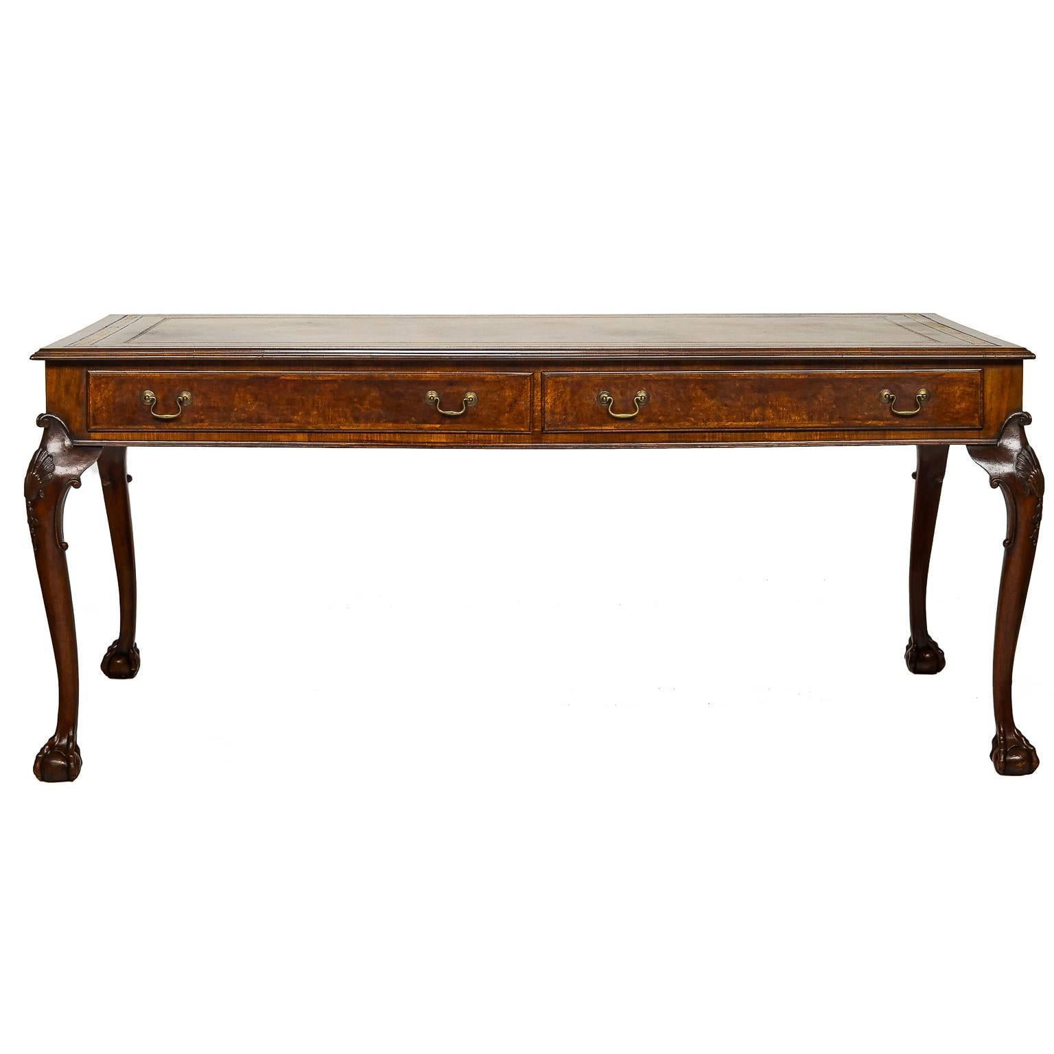 A handsome 19th century Chippendale style writing desk with a leather top. The leather has fantastic blind and gold tooling from a one piece hide. The are drawers on both side which are functional. This gives the functionality of a partners style