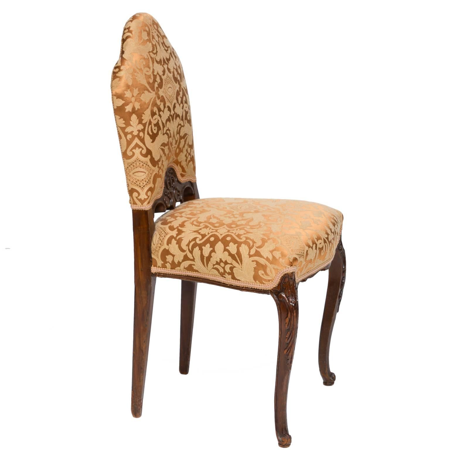 A delightful Louis XV style walnut vanity chair. Wonderful shaped back, notice the panel carved between the supports. Carved cabriole legs. Recent covering in a vintage style fabric. Very sturdy.