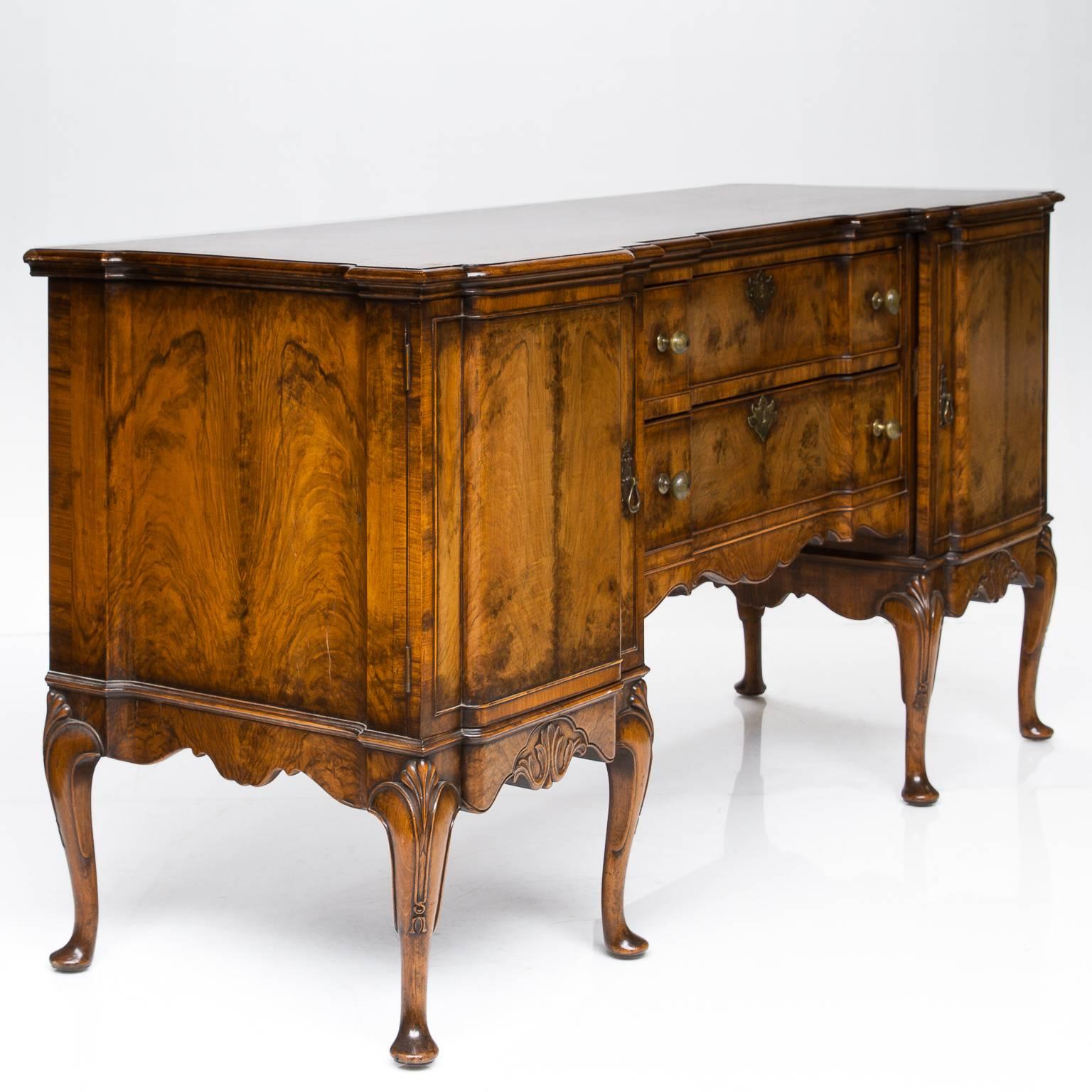 A very high quality 19th century Queen Anne walnut serving sideboard. This server is made of figured bleached walnut and interior quality oak. The server has a breakfront which the centre is set back. Giving the ends a pedestal look. There are two