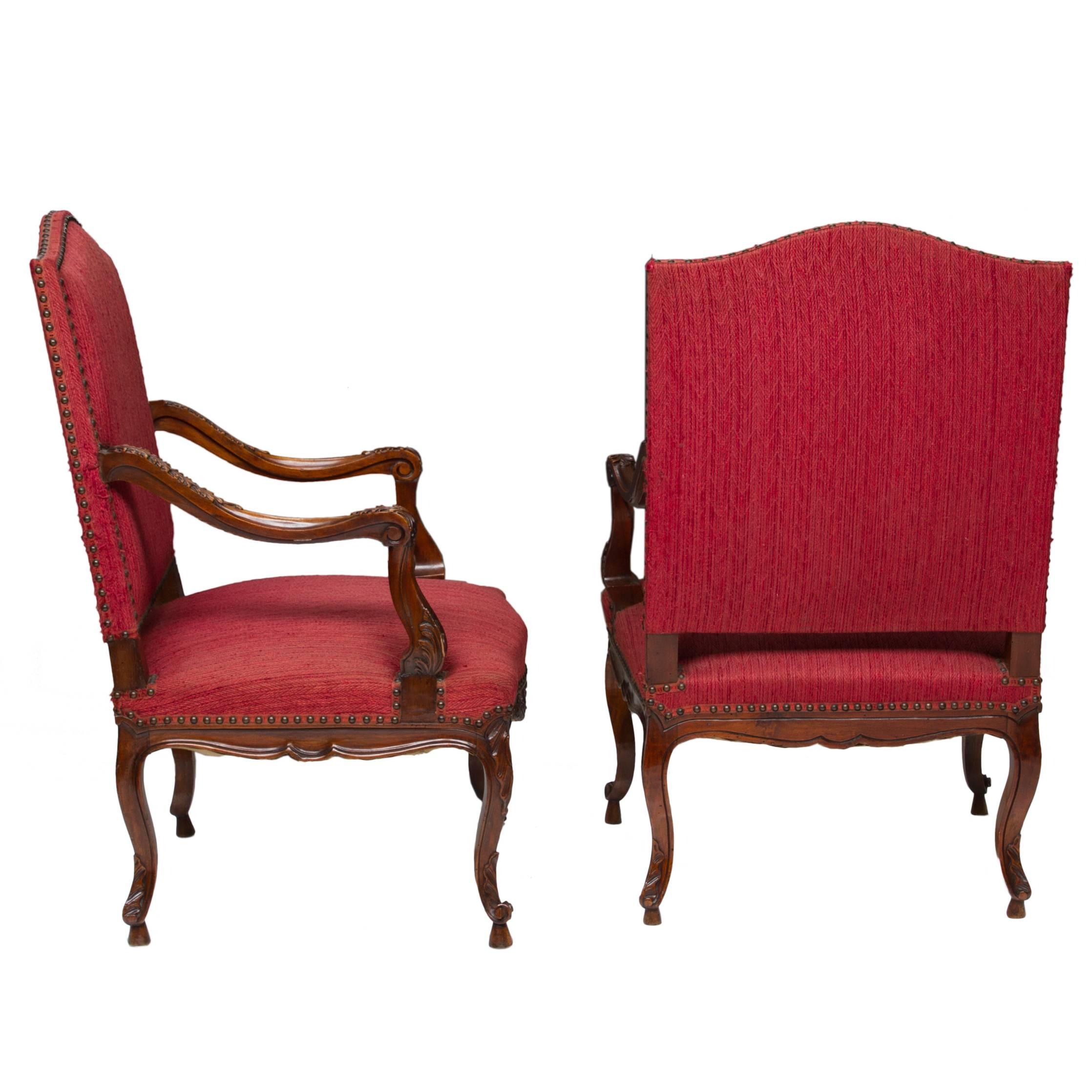 A great pair of Louis XV walnut fauteuil's with a shaped flat back, dipped and carved wood arm pad, set back arm support, carved cusp of the front rail. Turned out scroll resting on a shoe and fabric in very useable condition. The wooden frame is