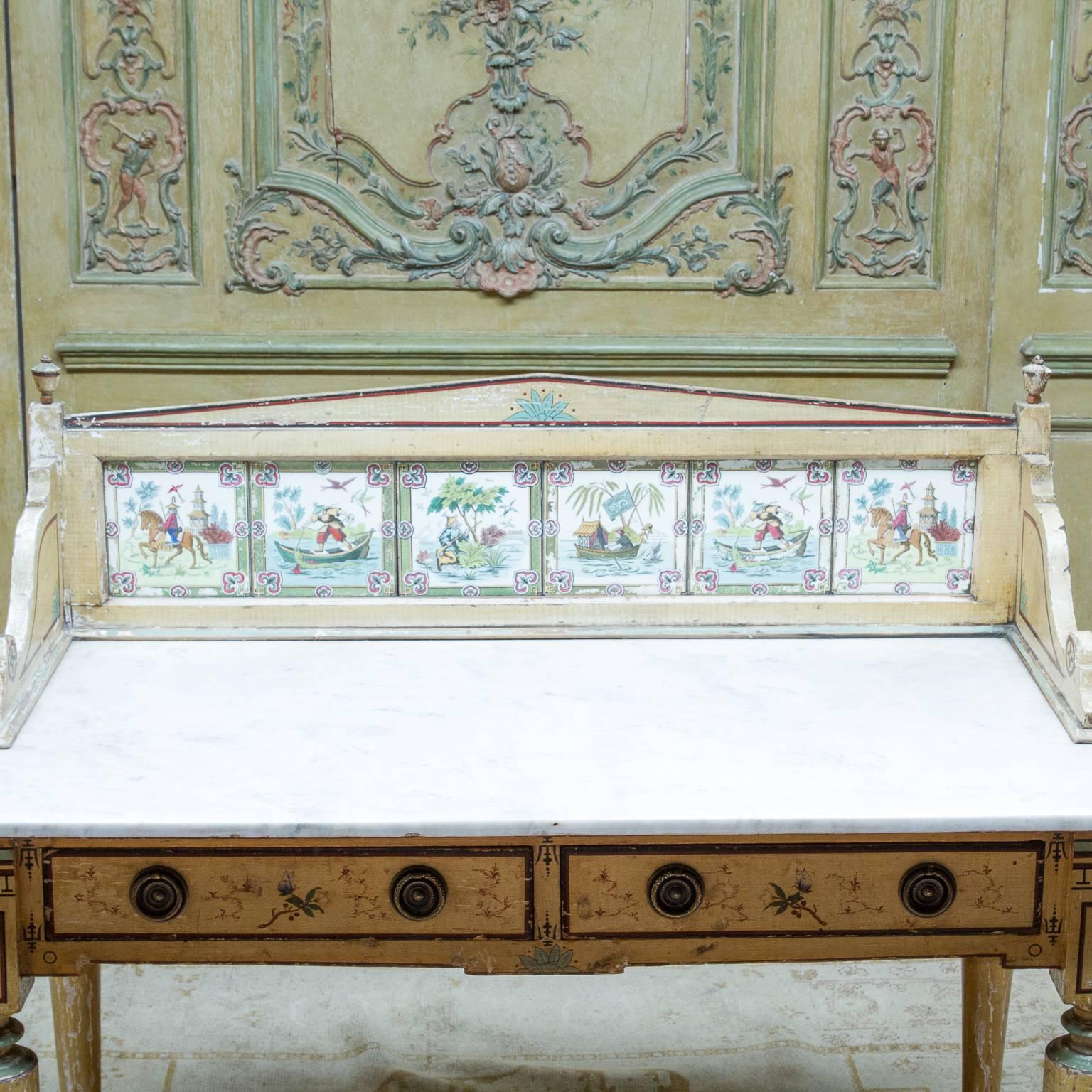19th century English marble top painted washstand or side table with an oriental look. Wonderful old paint worn well. Marble no cracks. Nice decorative splash back having six painted porcelain plaques. Two drawers and resting on castors.
