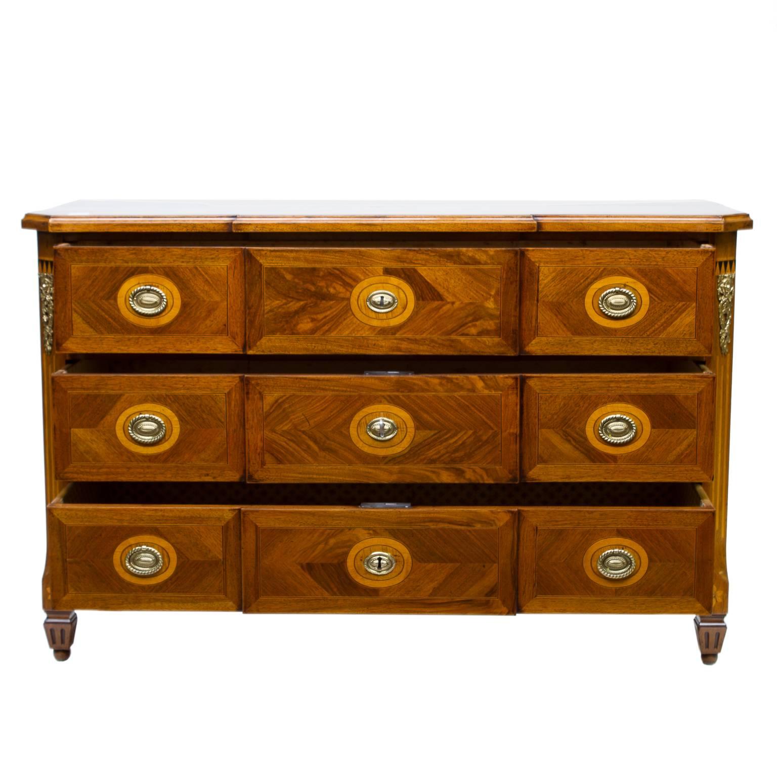 19th century Italian walnut three-drawer breakfront commode. This commode is decorated with figured cuts of quality woods. Giving the dramatic look. The front has oval pulls surrounded by oval inlays (nice touch). Corners chamfered with inlays